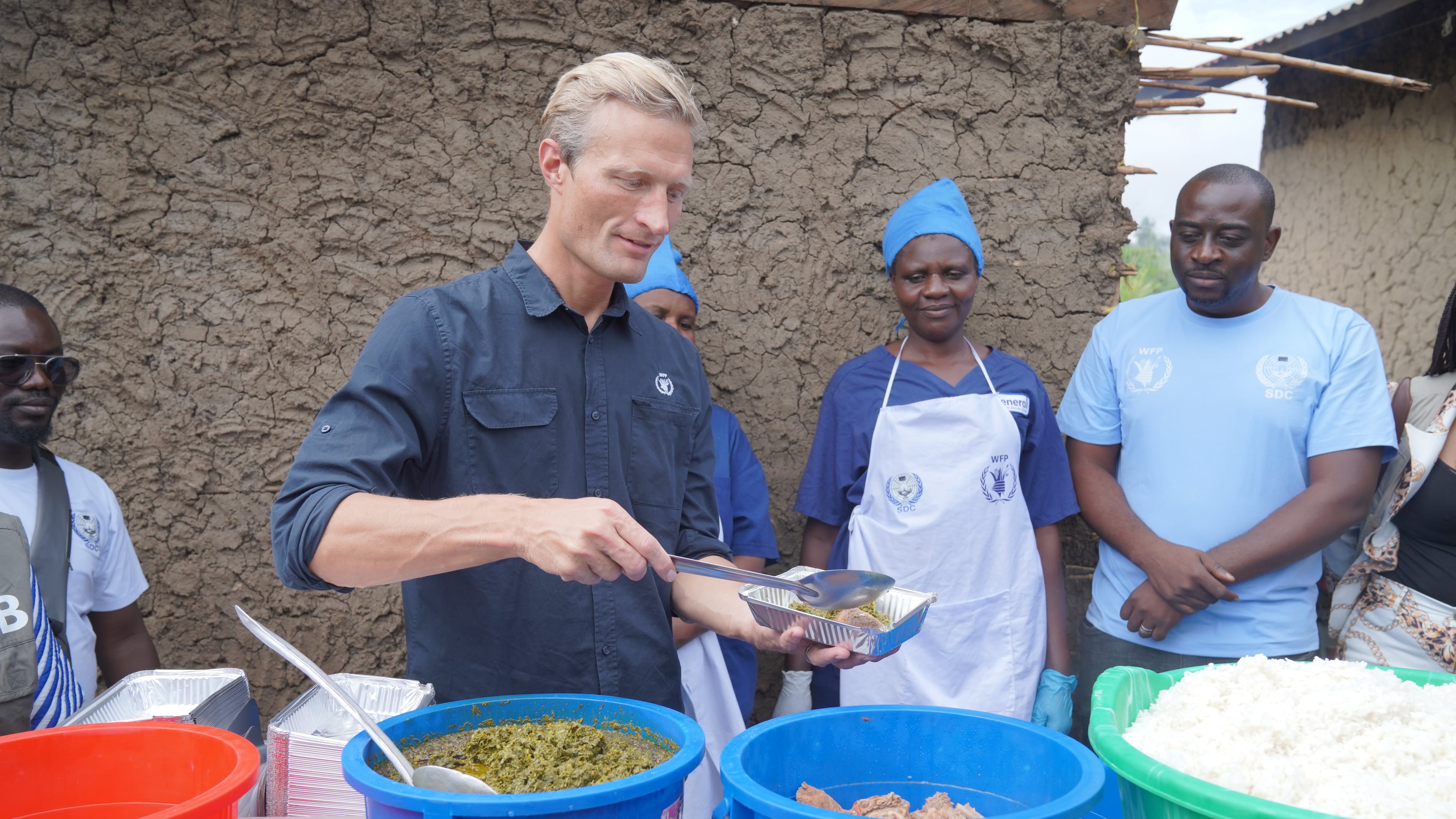 Carl Skau, acting executive director of the World Food Programme, pepares a container of food at the Rwampara Ebola treatment center in Ituri, eastern Congo, Wednesday, July 29, 2026. (AP Photo/Dieudonne Dirole)