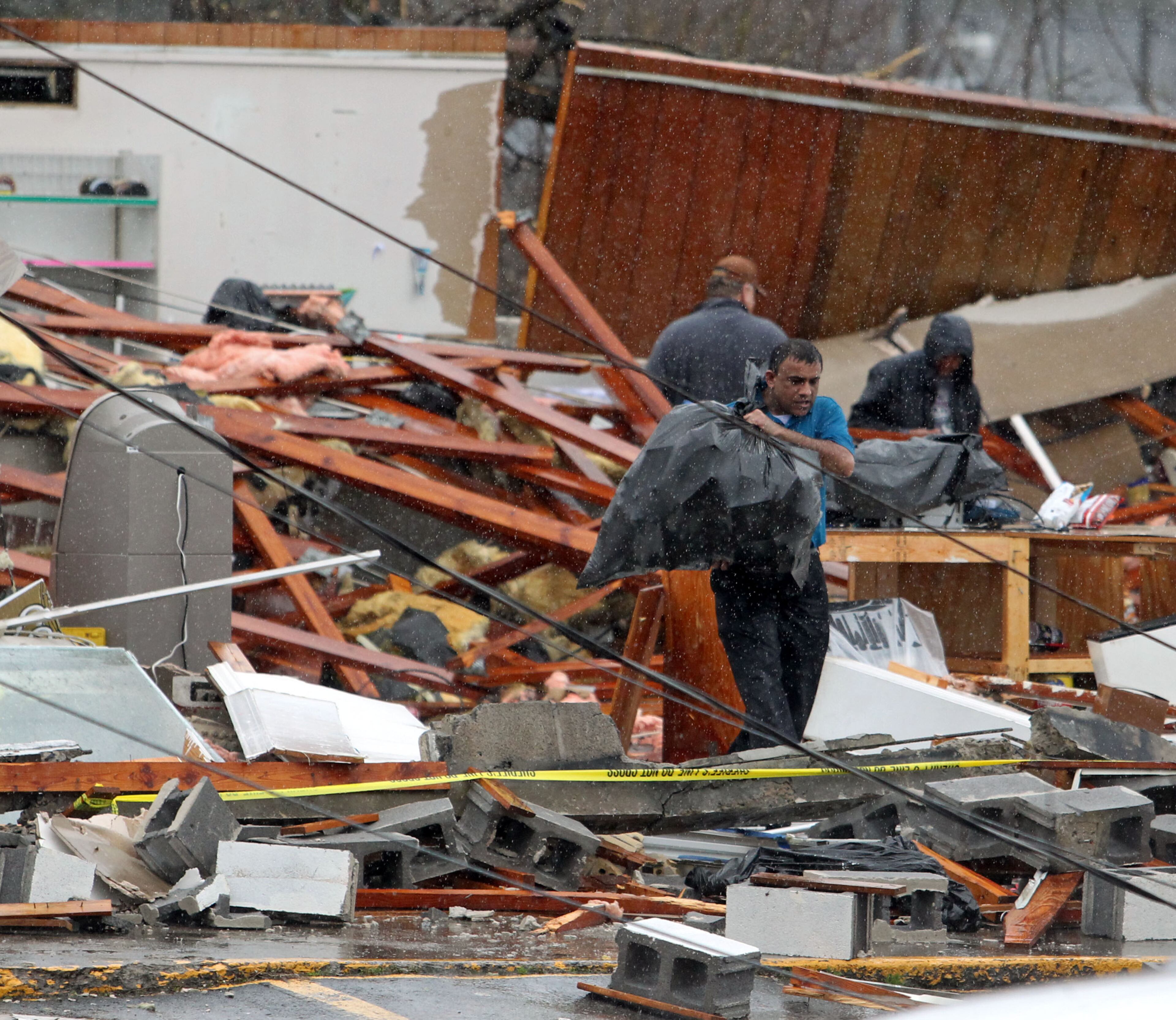 People with Adairsville Grocery help salvage products from the store after it was damaged by a tornado on Highway 41 Wednesday afternoon in Adairsville, Ga. Locals said the storm hit around 11:30am. JASON GETZ / JGETZ@AJC.COM