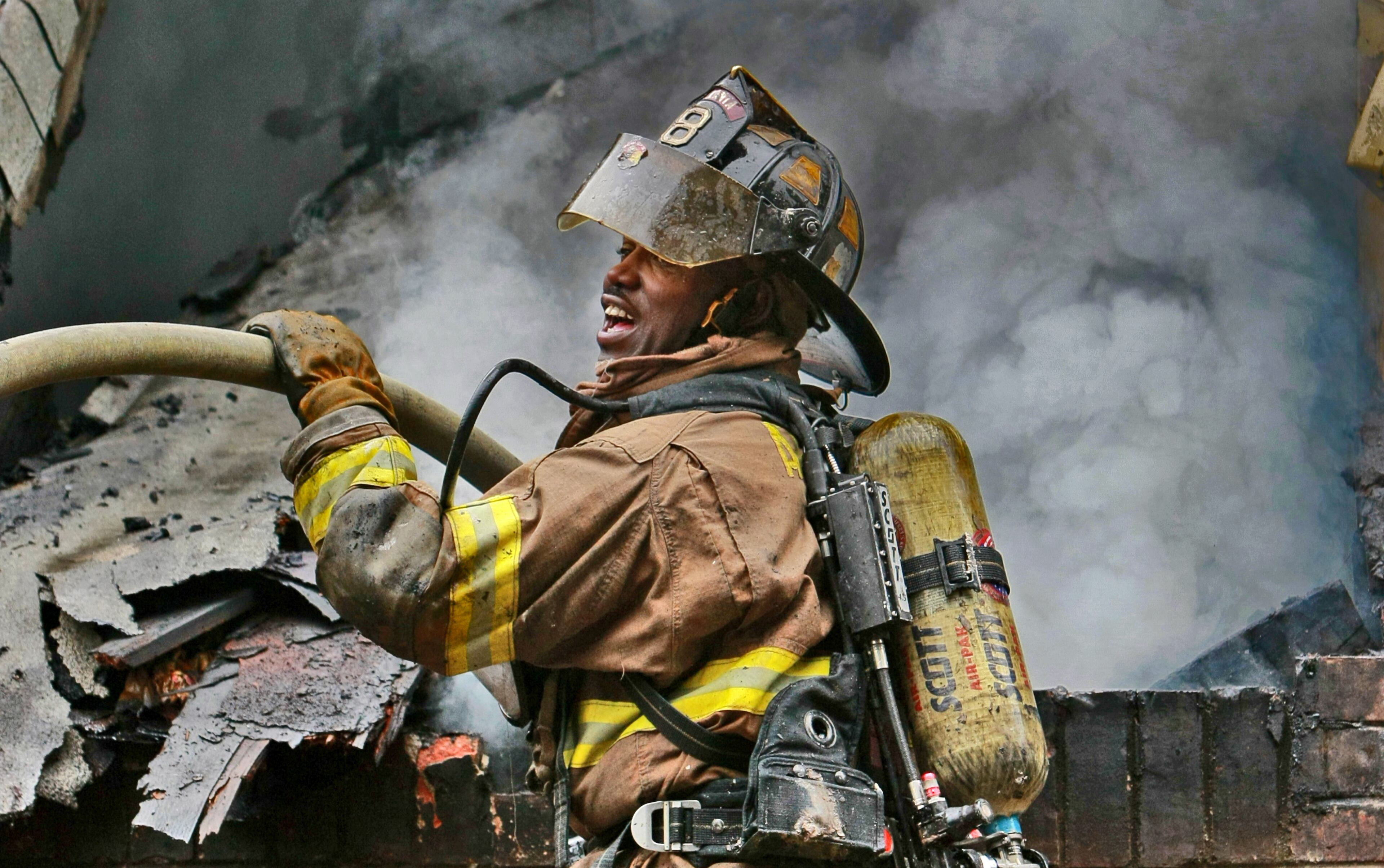 090831 - Atlanta - Atlanta firefighter, Dedric Cummings of Truck 14 asks for more slack as he attacks a stubborn fire Monday. A two-alarm fire was brought under control just after 9AM Monday morning, August 31, 2009 at 568 English Avenue near North Avenue where Atlanta firefighters declared the building free and clear after doing their primary searches and discovering the occupant of an only apartment located in the building outside the structure safe and unharmed. The structure was a two-story building that contained a grocery store and barber shop both with no markings according to Atlanta Fire Captain Bill May. Former city council woman Mabel Thomas who was walking in the neighborhood said the grocery store had been there for thirty years. The alarm came in at 7:32 AM and is under investigation. There were no injuries reported. John Spink, jspink@ajc.com