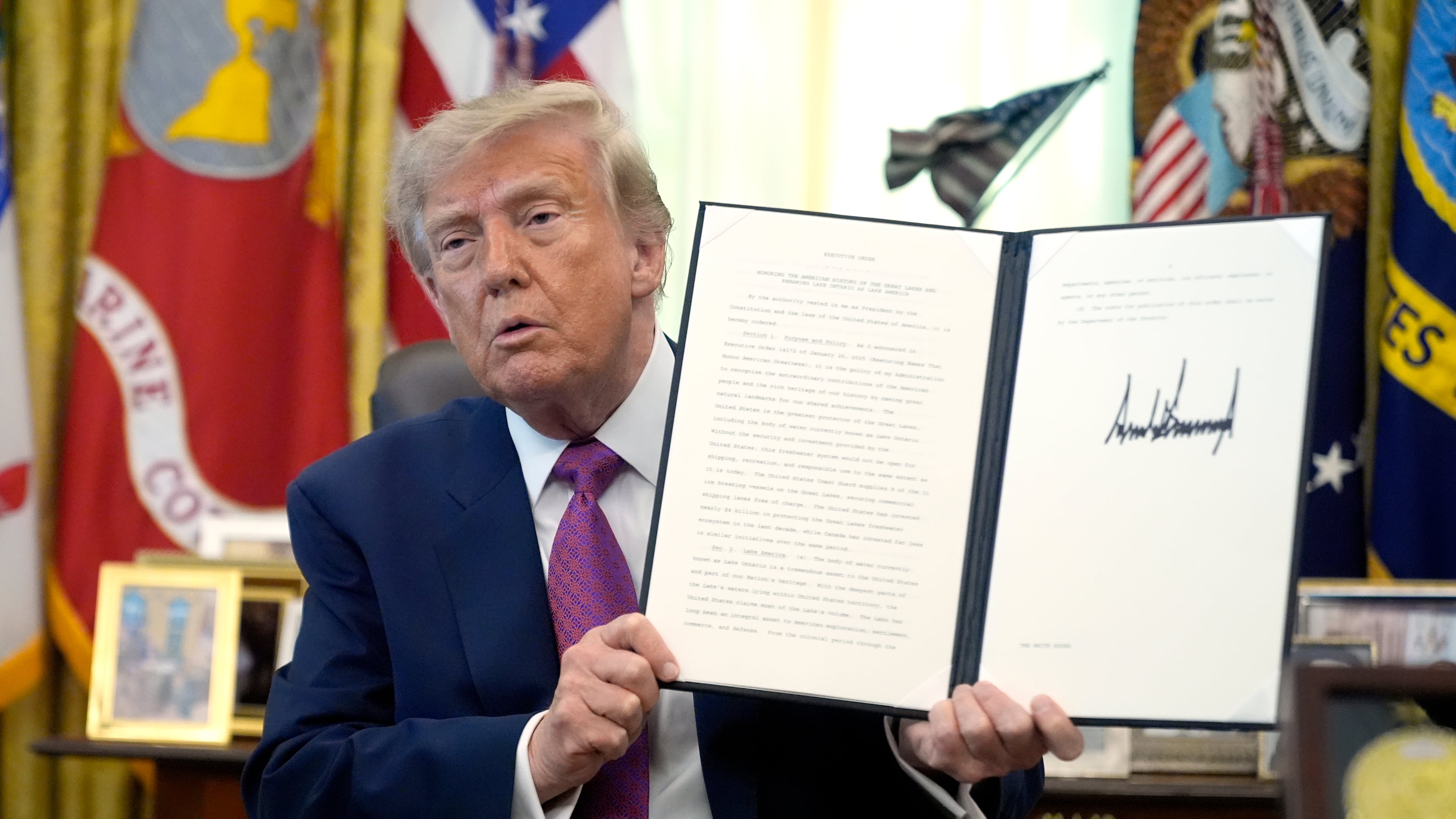President Donald Trump holds up a signed executive order in the Oval Office of the White House, Thursday, Aug. 27, 2026, in Washington. (AP Photo/Manuel Balce Ceneta)