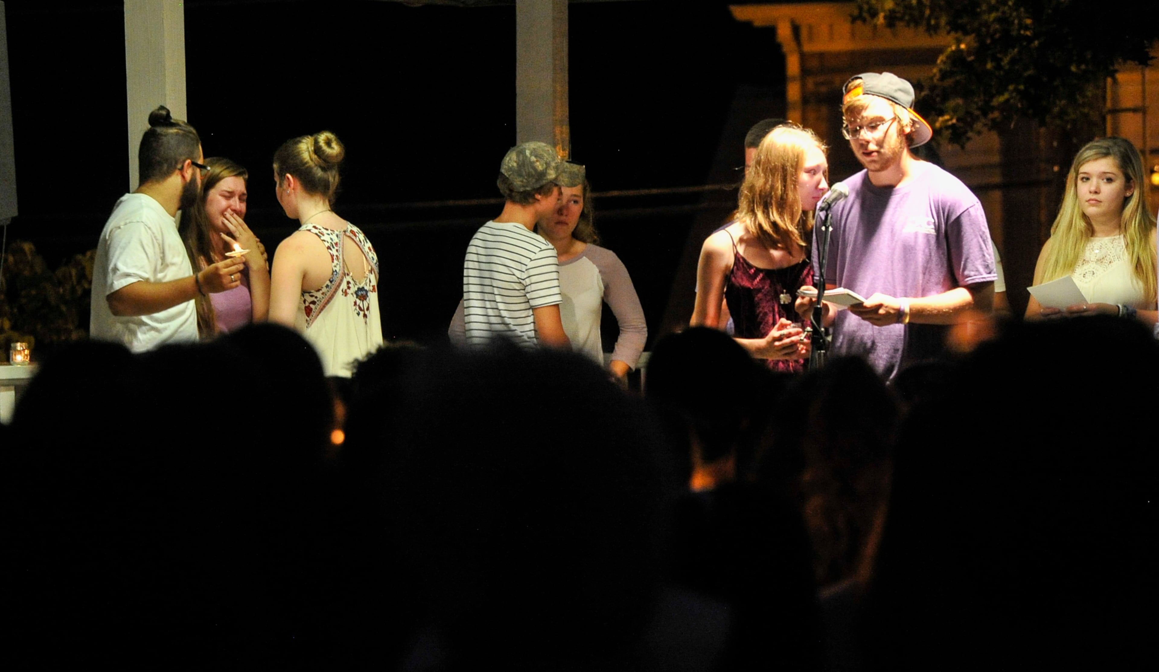 Friends of Natalie Henderson gather on the stage to say words during a vigil held for her on the old Roswell Square, Thursday, Aug. 4, 2016. Henderson, of Roswell, and Carter Davis of Woodstock, both 17, were found Monday behind a Publix grocery store shot to death. Jeffrey A. Hazelwood, 20, was arrested Wednesday and will be charged with two counts of murder in the deaths. (Photo Contributed by John Amis)
