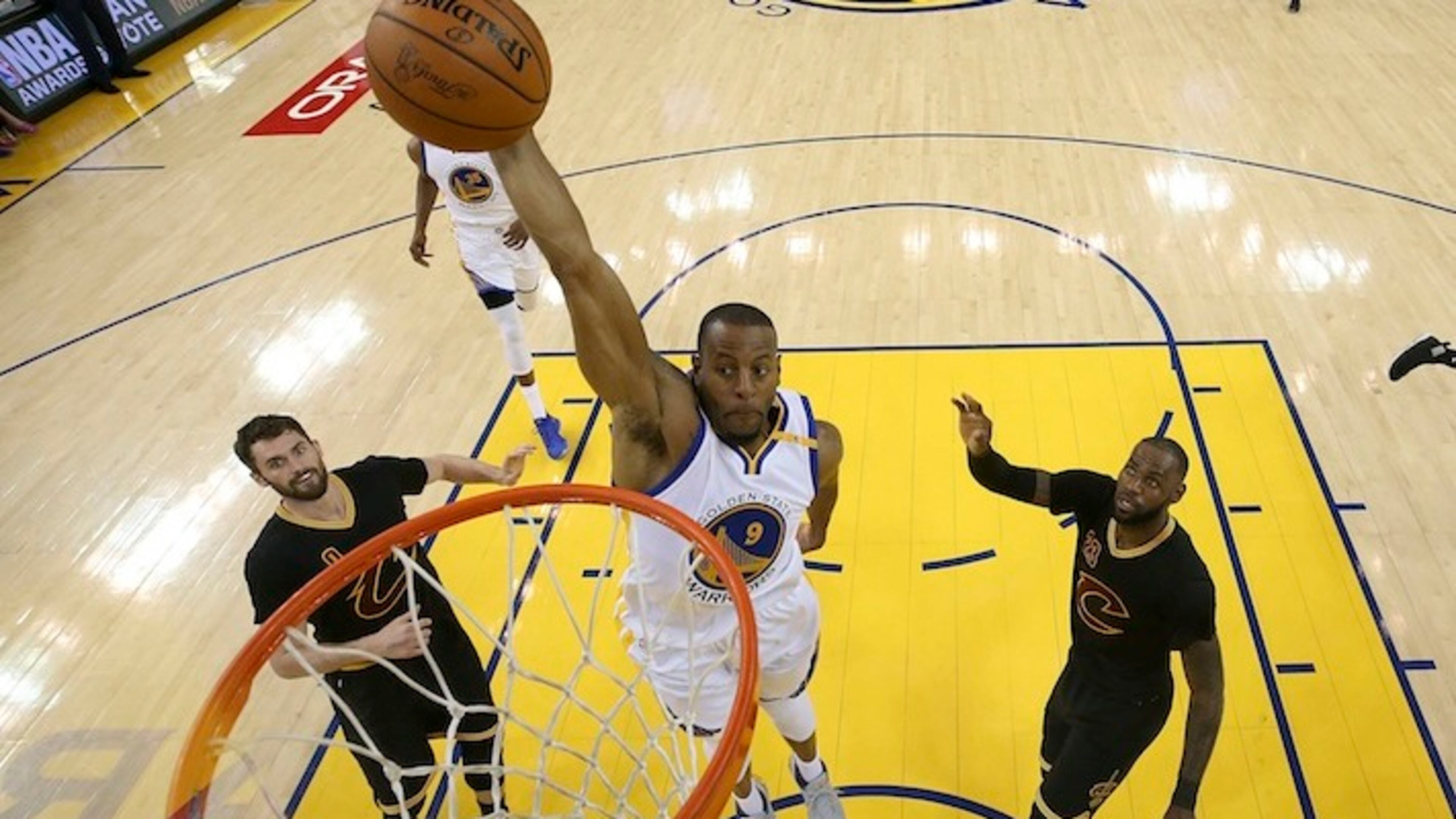 Golden State Warriors forward Andre Iguodala (9) dunks between Cleveland Cavaliers forward Kevin Love (0) and forward LeBron James (23) during the first half of Game 5 of basketball's NBA Finals in Oakland, Calif., Monday, June 12, 2017. (Ezra Shaw/Pool Photo via AP)