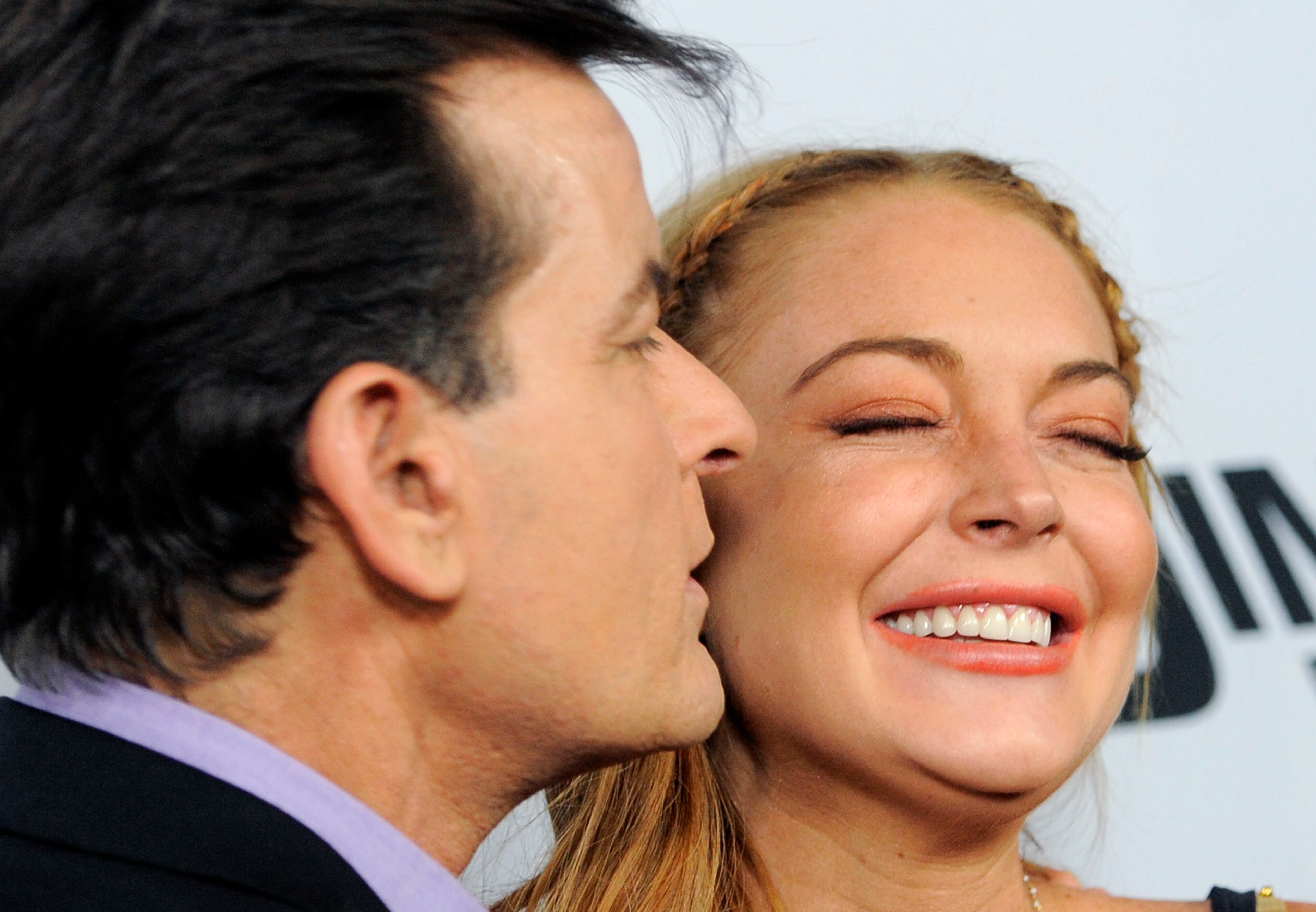 Lindsay Lohan, right, a cast member in "Scary Movie V," gets a kiss from fellow cast member Charlie Sheen at the Los Angeles premiere of the film at the Cinerama Dome on Thursday, April 11, 2013 in Los Angeles.