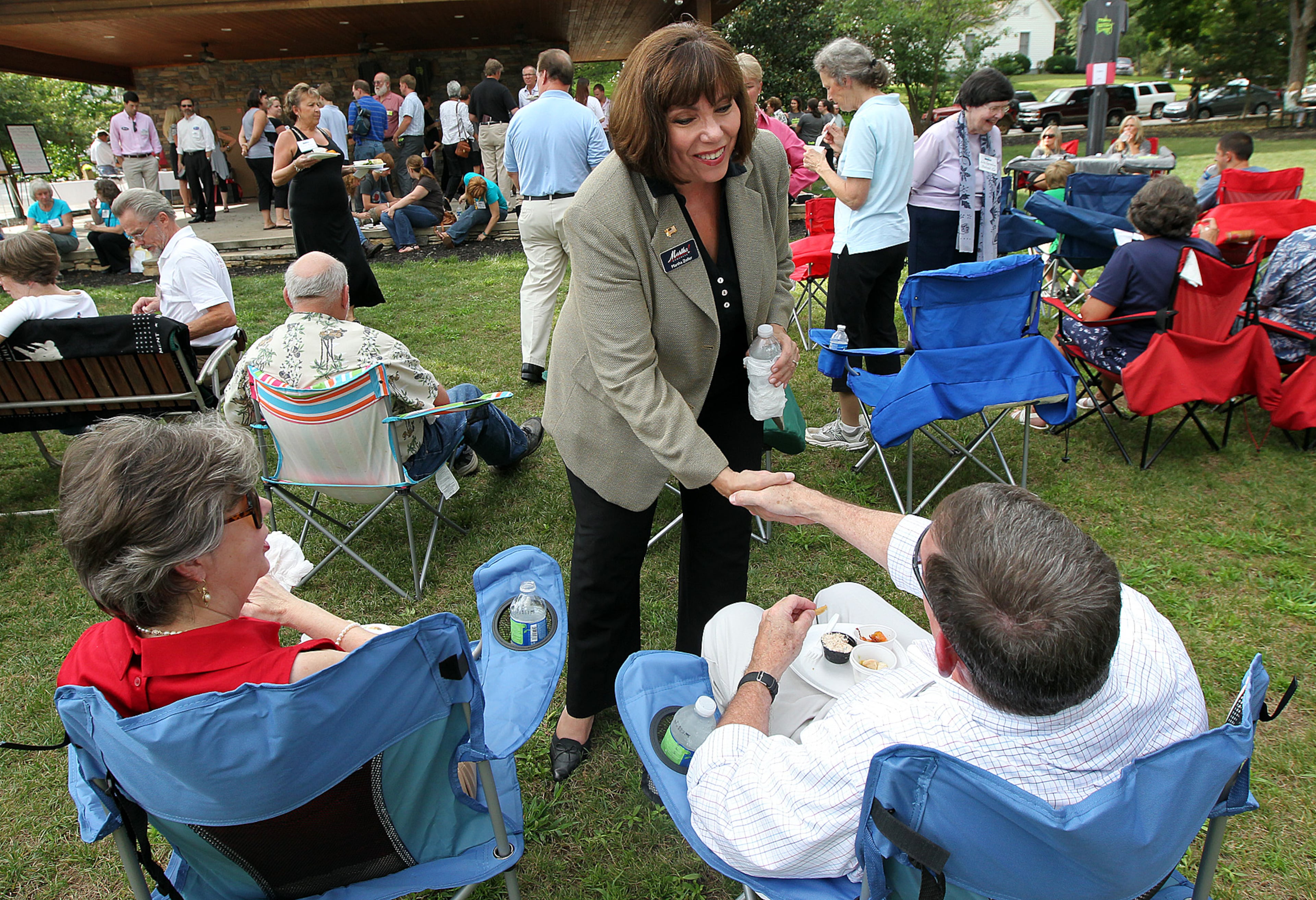 Martha Zoller, candidate for the 9th congressional seat, shakes hands with Terry Dawson with his wife Marie Dawson looking on while working the crowd for votes at the Dahlonega-Lumpkin Chamber After Hours event on Tuesday, Aug. 7, 2012.