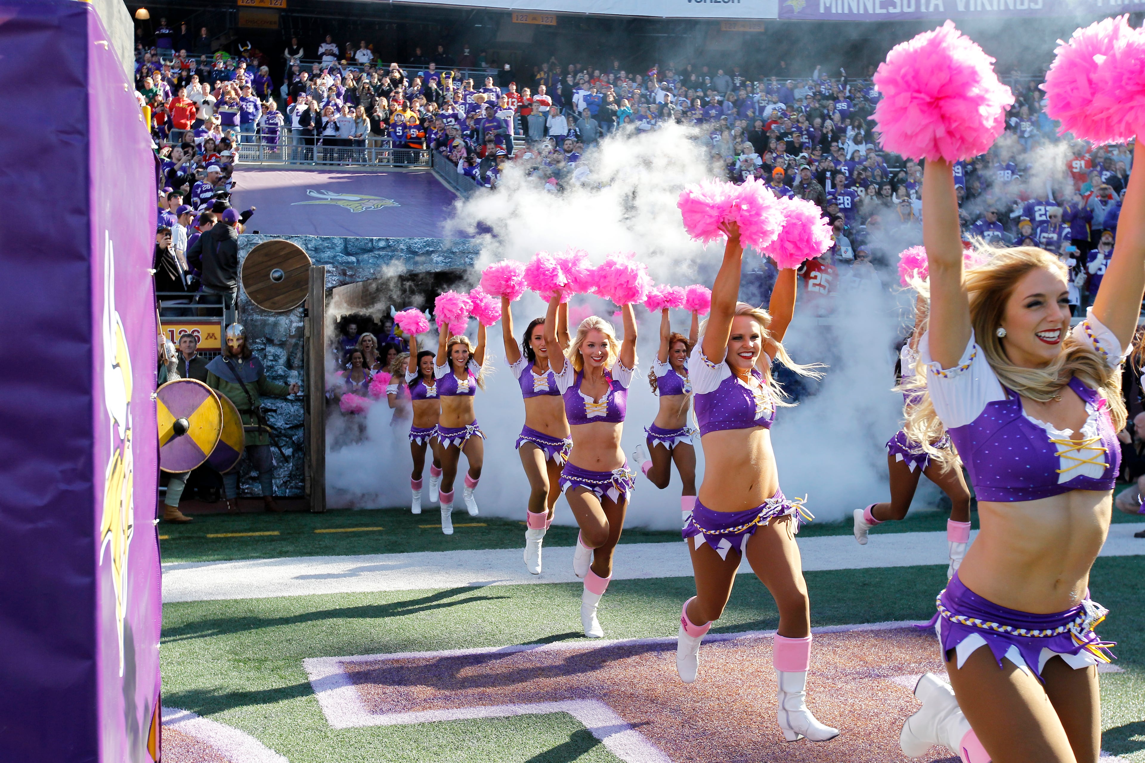 Minnesota Vikings cheerleaders with pink pom-poms for breast cancer awareness, enter the field before an NFL football game against the Kansas City Chiefs, Sunday, Oct. 18, 2015, in Minneapolis. (AP Photo/Ann Heisenfelt)