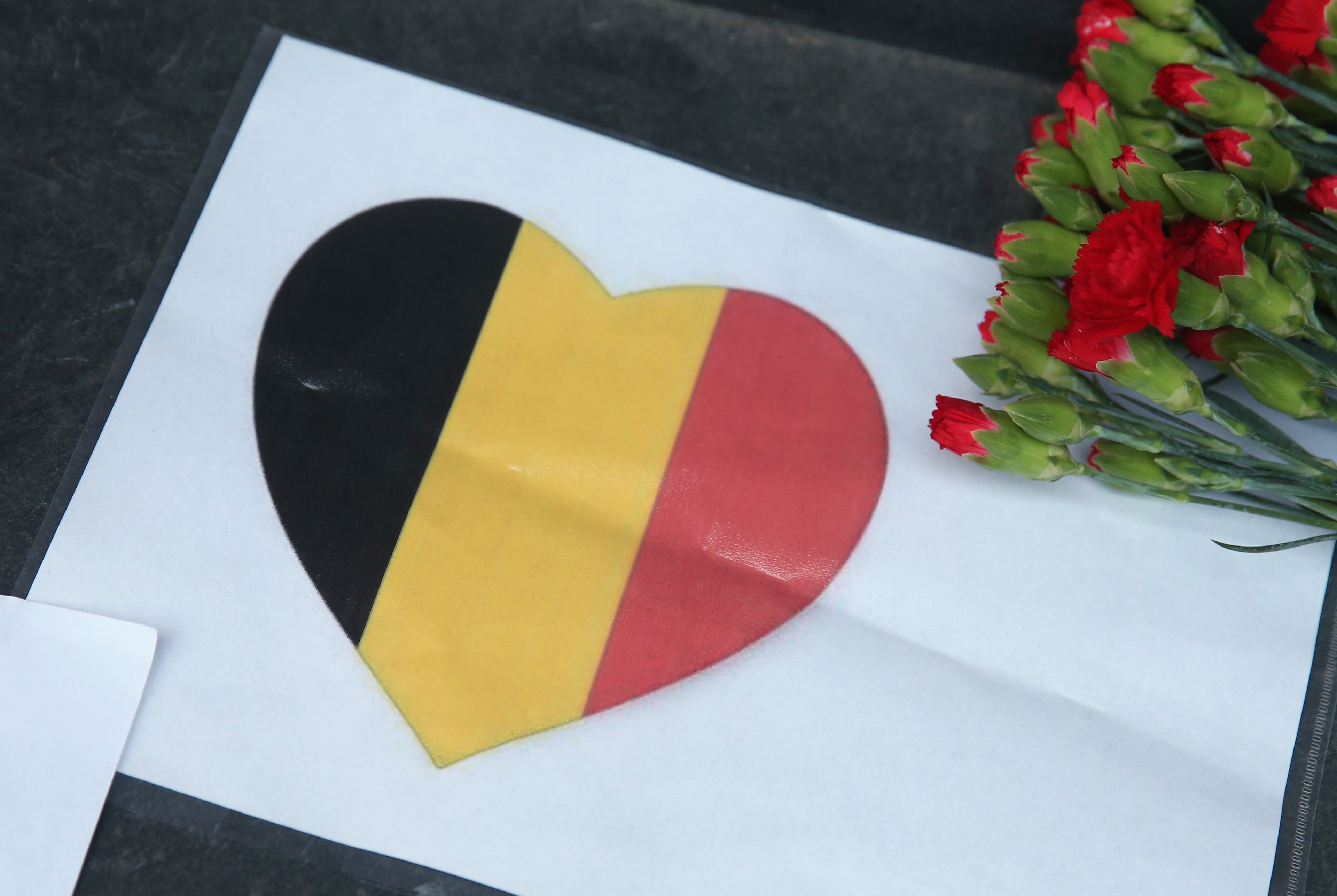BERLIN, GERMANY - MARCH 22: A heart with the colors of the Belgian flag lies among flowers at the steps of the Belgian Embassy following today's terrorist attacks in Brussels on March 22, 2016 in Berlin, Germany. The Islamic State has claimed responsibility for the attack in which terrorists detonated three explosives devices at Brussels airport and in a metro train and killed at least 30 people. (Photo by Sean Gallup/Getty Images)