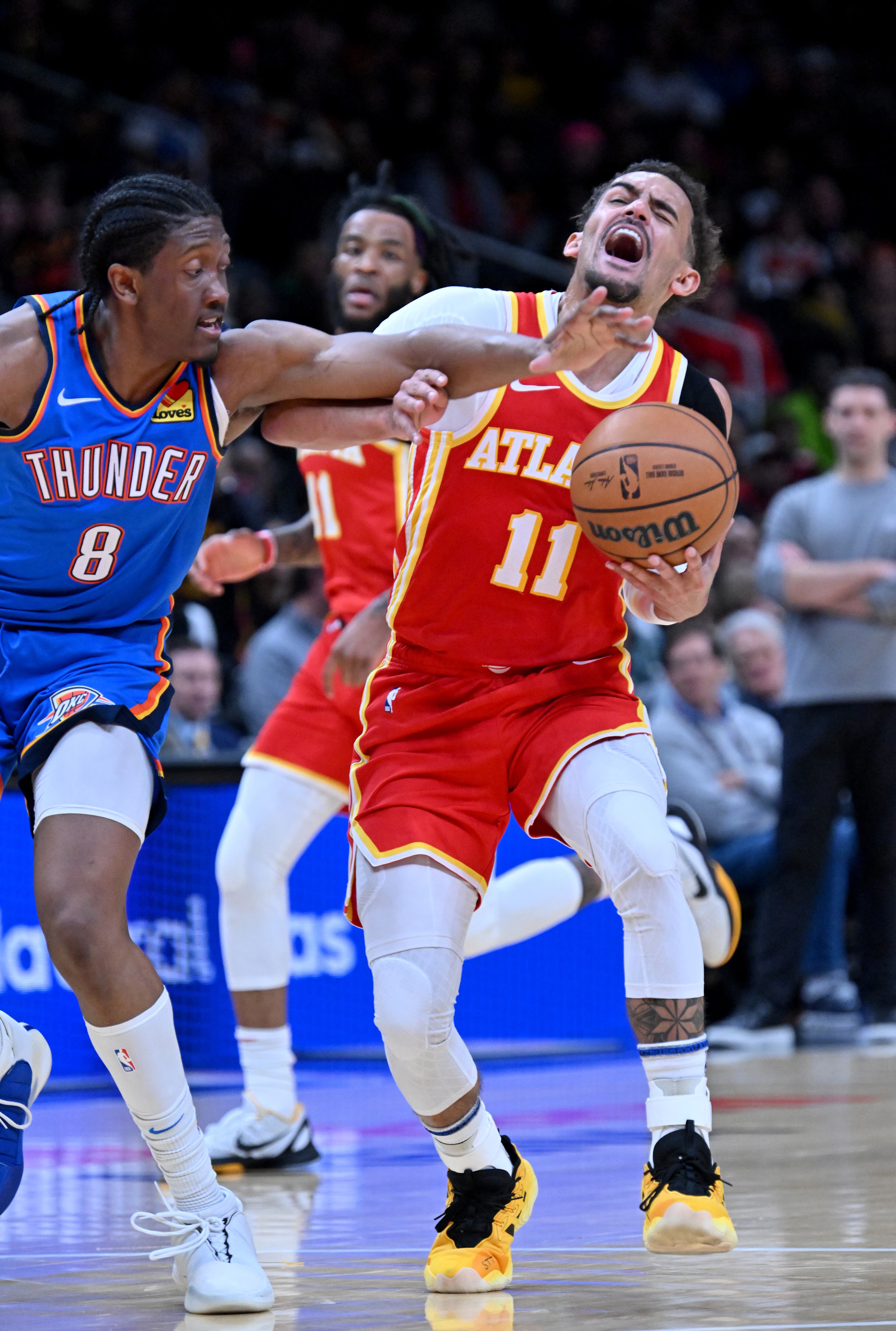 Atlanta Hawks guard Trae Young (11) is fouled by Oklahoma City Thunder forward Jalen Williams (8) as he drives during the first half in an NBA basketball game at State Farm Arena, Wednesday, December 3, 2024, in Atlanta. (Hyosub Shin / Hyosub.Shin@ajc.com)