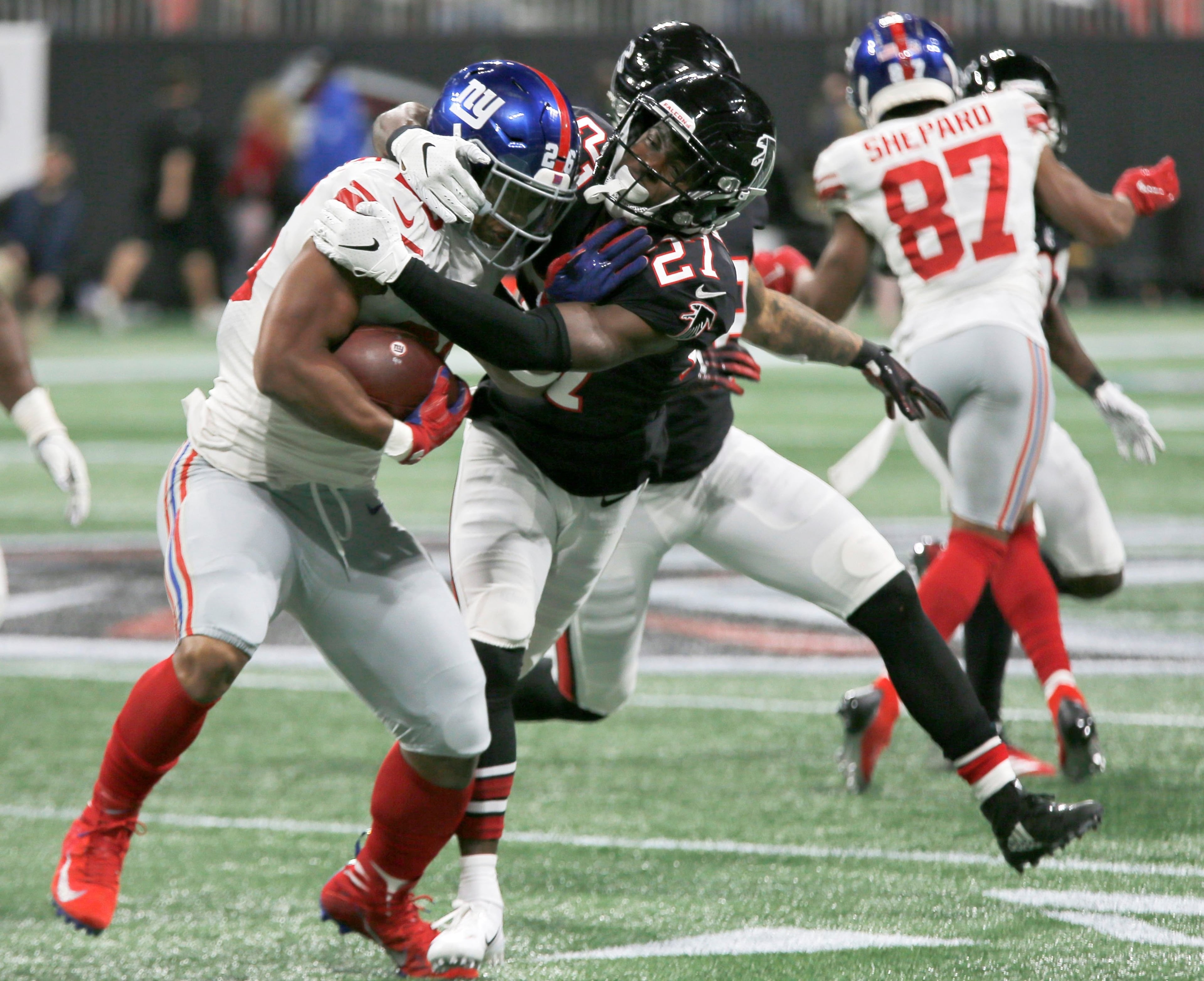 10/22/18 - Atlanta - Atlanta Falcons cornerback Desmond Trufant (21) puts the stop on New York Giants running back Saquon Barkley (26) in the first half. The Atlanta Falcons played the New York Giants in an NFL football game Monday, October 22, 2018, at Mercedes-Benz Stadium in Atlanta, GA. BOB ANDRES / BANDRES@AJC.COM