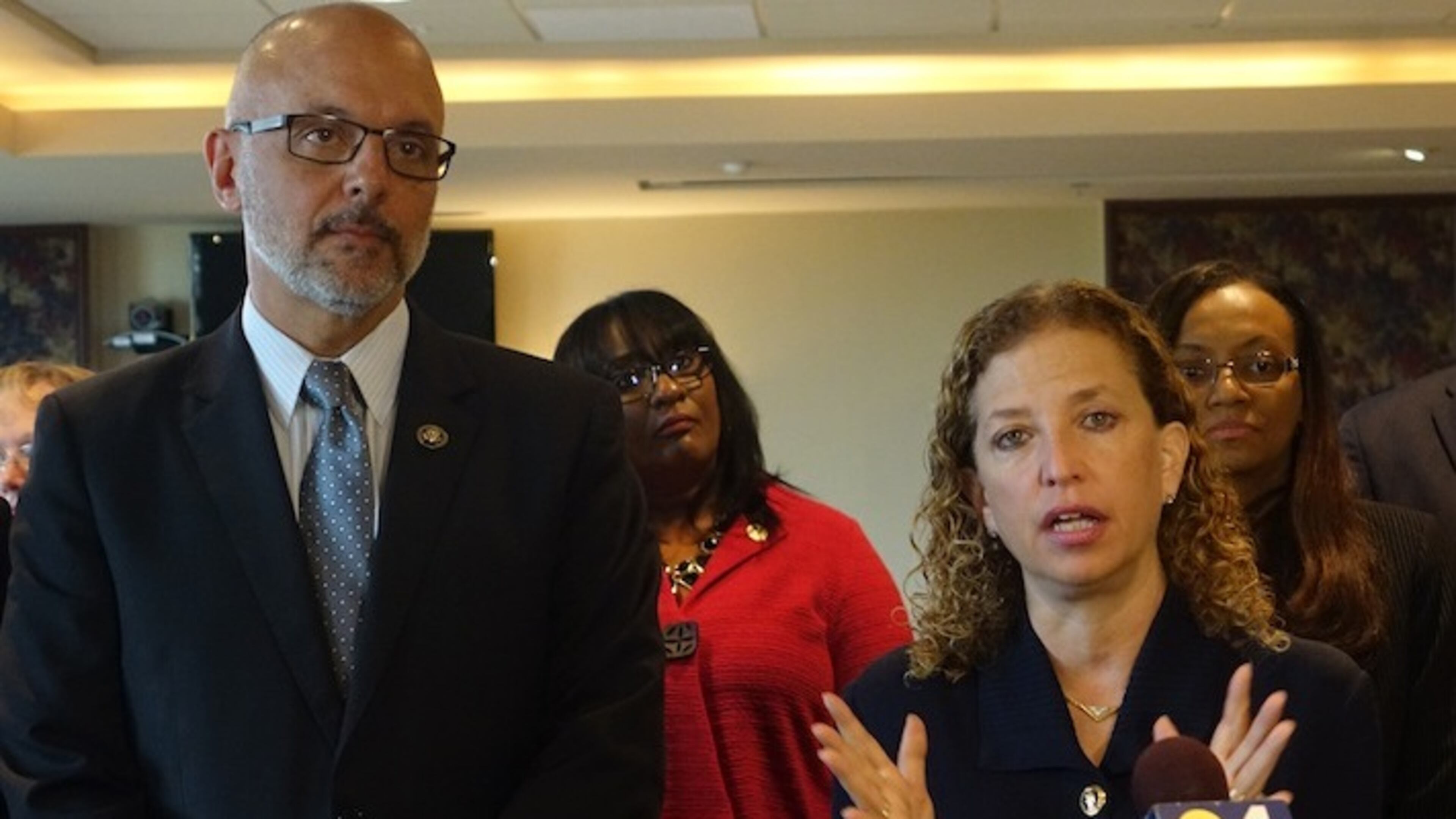 U.S. Rep. Debbie Wasserman Schultz, D-Fla., speaks as Rep. Ted Deutch looks on, Monday, June 6, 2016, at Nova Southeasten Univesity in Davie, Fla., during a round table event about the Zika virus. Florida will experience a "disaster" with the Zika virus if federal authorities don't immediately provide money to help battle the virus, Florida Gov. Rick Scott said Wednesday. (Joe Cavaretta/South Florida Sun-Sentinel via AP) MAGS OUT; MANDATORY CREDIT