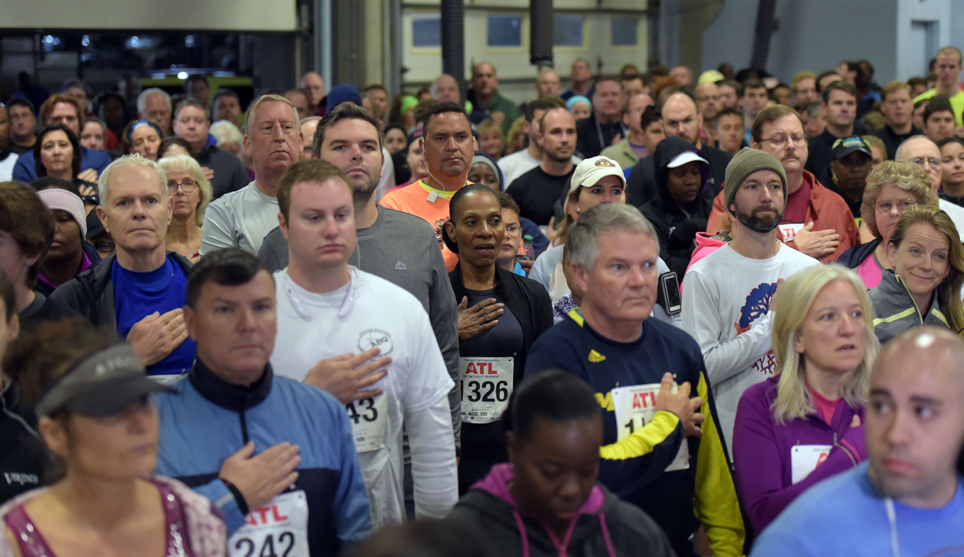 OCTOBER 17, 2015 ATLANTA Runners stand for the National Anthem inside Atlanta Fire Station #33 prior to the race. Mayor Kasim Reed and United Way President Milton Little joined more than 2,000 runners at the Mayor’s Inaugural 5K on the 5th Runway at the world’s busiest airport Saturday, October 17, 2015. Airport officials shut down the 5th runway (Runway 10/28) until 8:15 am so runners and walkers could exit the course. All proceeds from the event will benefit United Way of Greater Atlanta. Major sponsors of The Mayor’s Inaugural 5K on the 5th Runway include Delta Air Lines, The Coca-Cola Company, Enterprise Rental Car, Georgia International Convention Center, MARTA, and Publix. Over $123,000 was raised, said airport spokesman Reese McCranie. The race's overall winner was Andrew Murfee, 15, a Woodward Academy student. KENT D. JOHNSON/KDJOHNSON@AJC.COM