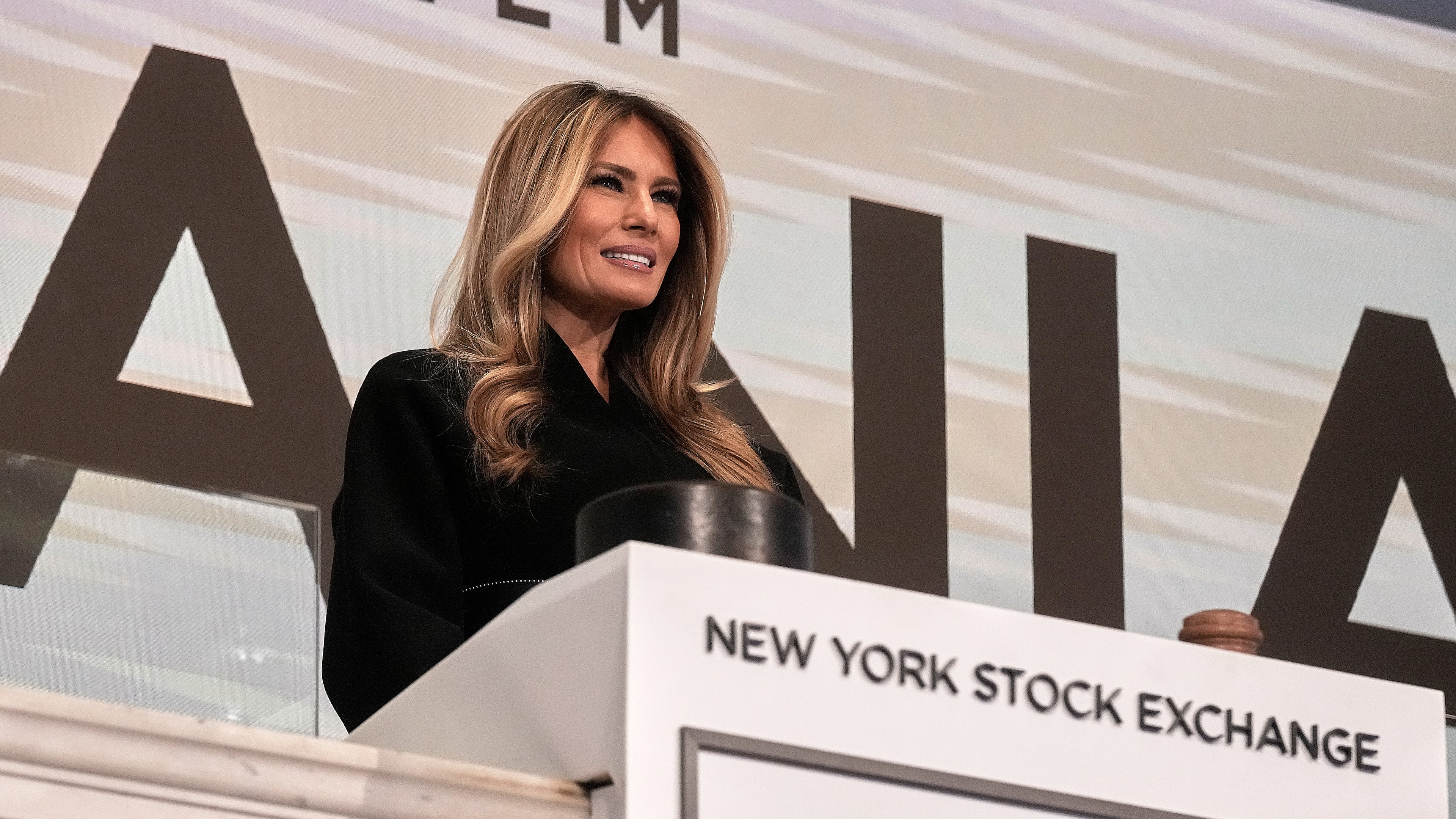 First lady Melania Trump poses for photos on the podium after ringing the New York Stock Exchange opening bell, Wednesday, Jan. 28, 2026. (AP Photo/Richard Drew)