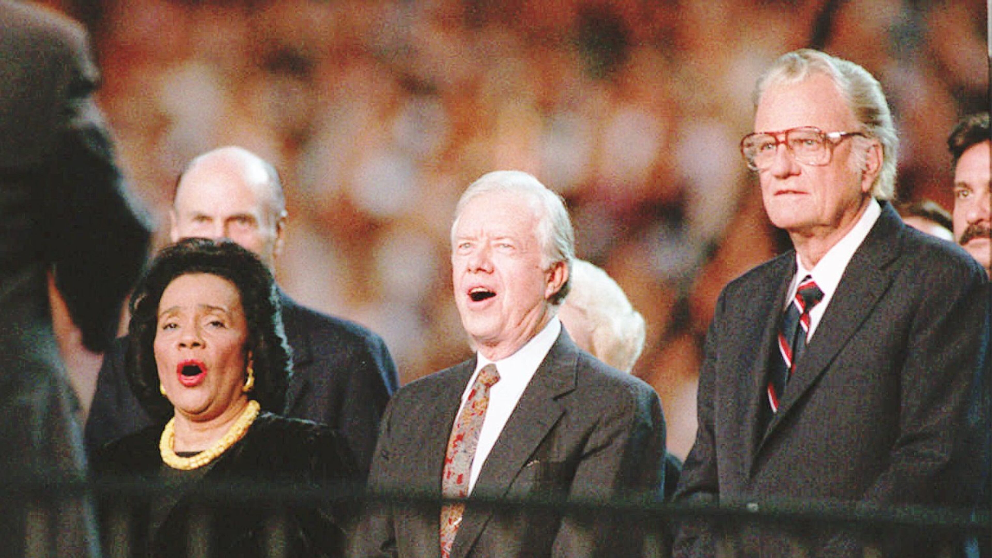 from left Coretta Scott King former President Jimmy Carter and Billy Graham stand and sing Blessed Assurance All Hail the Power at the Atlanta Billy Graham Crusade at the Georgia Dome Wednesday night About 49 800 people showed for the crusade on its first night in Atlanta Frank Niemeir Staff