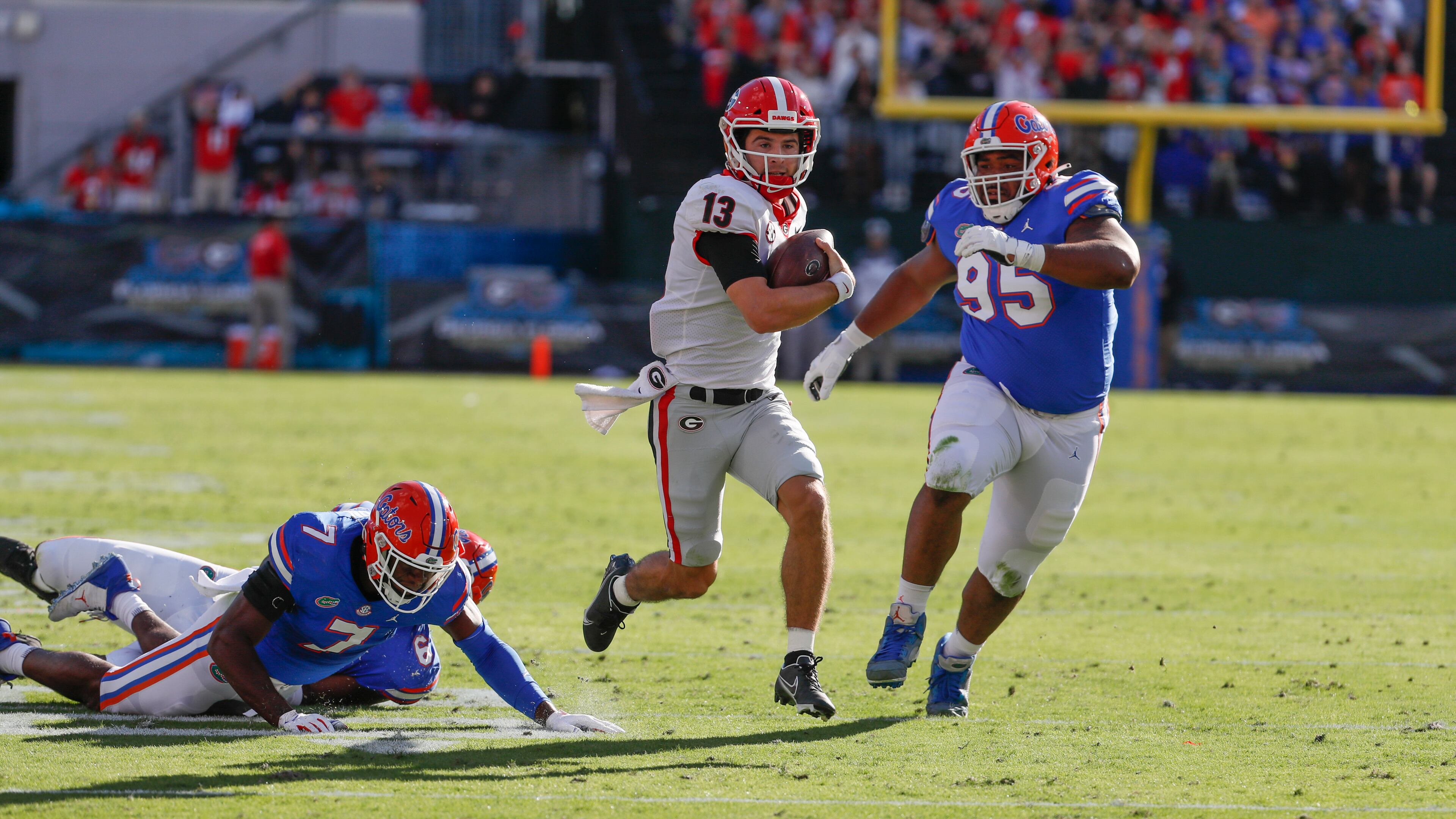 Georgia Bulldogs quarterback Stetson Bennett (13) scrambles for a first and goal during the first half of the annual NCCA Georgia vs. Florida game at TIAA Bank Field in Jacksonville. Bob Andres / bandres@ajc.com