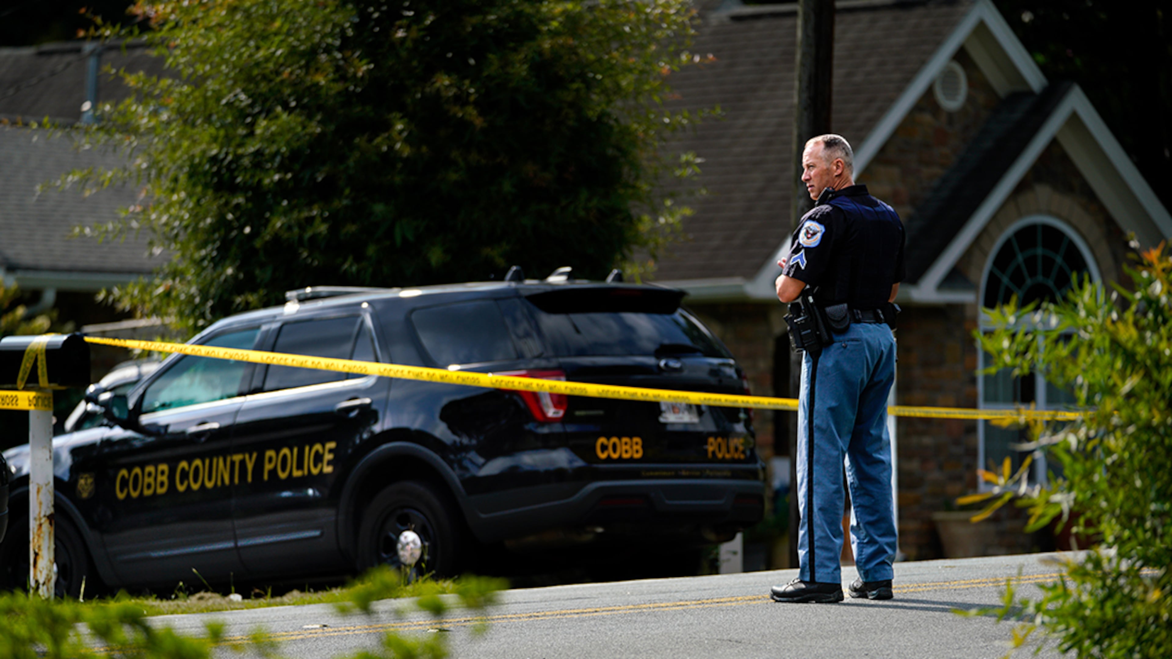 A Cobb County police officer stands outside at a shooting scene on Olive Spring Road. (Photo: Ben Hendren for The Atlanta Journal-Constitution)