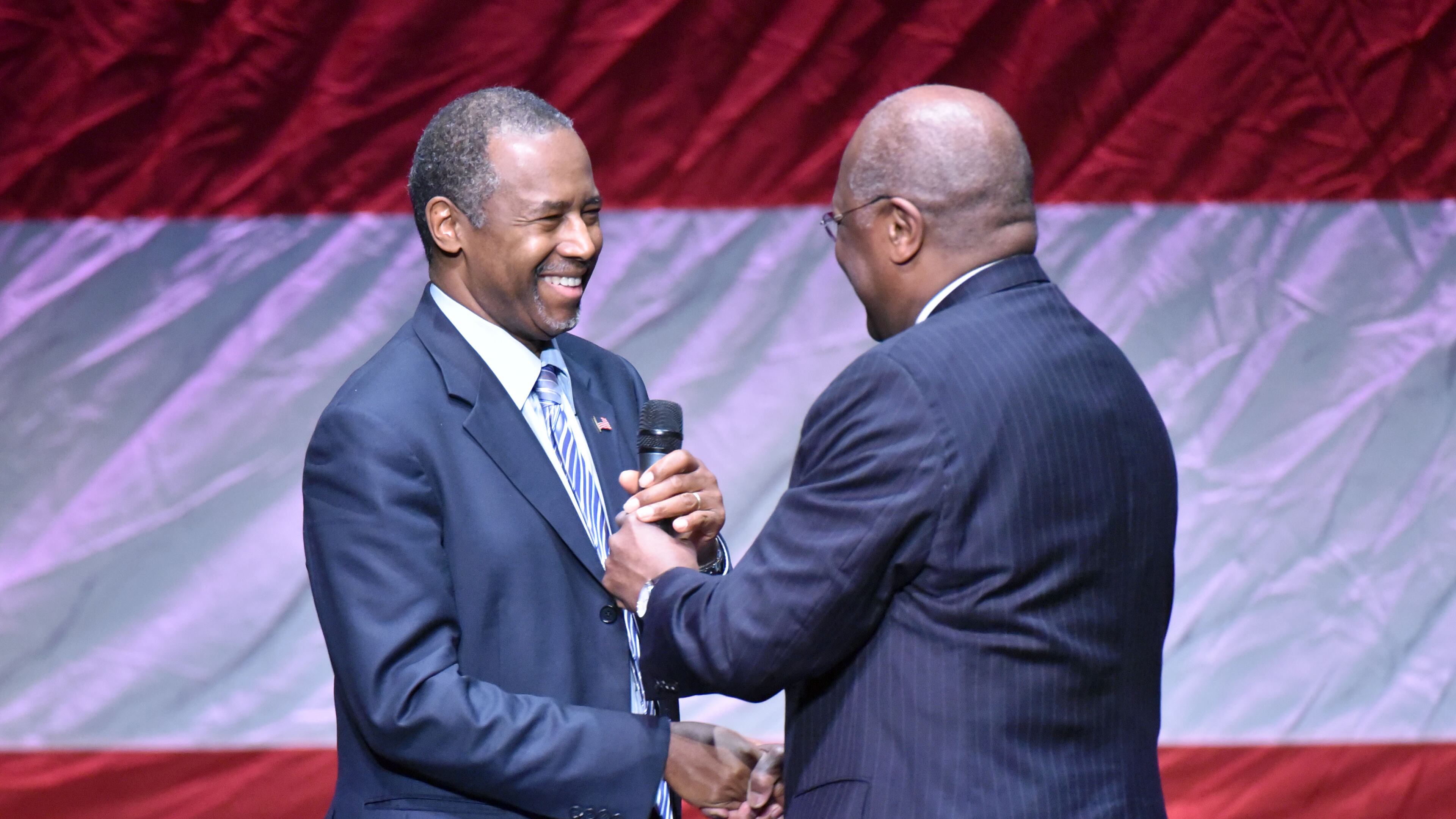 Republican presidential candidate Dr. Ben Carson (left) shakes hands with Herman Cain during Ben Carson For President 2016 Rally at Cobb Energy Center on Tuesday December 8, 2015.(AJC/Hyosub Shin)