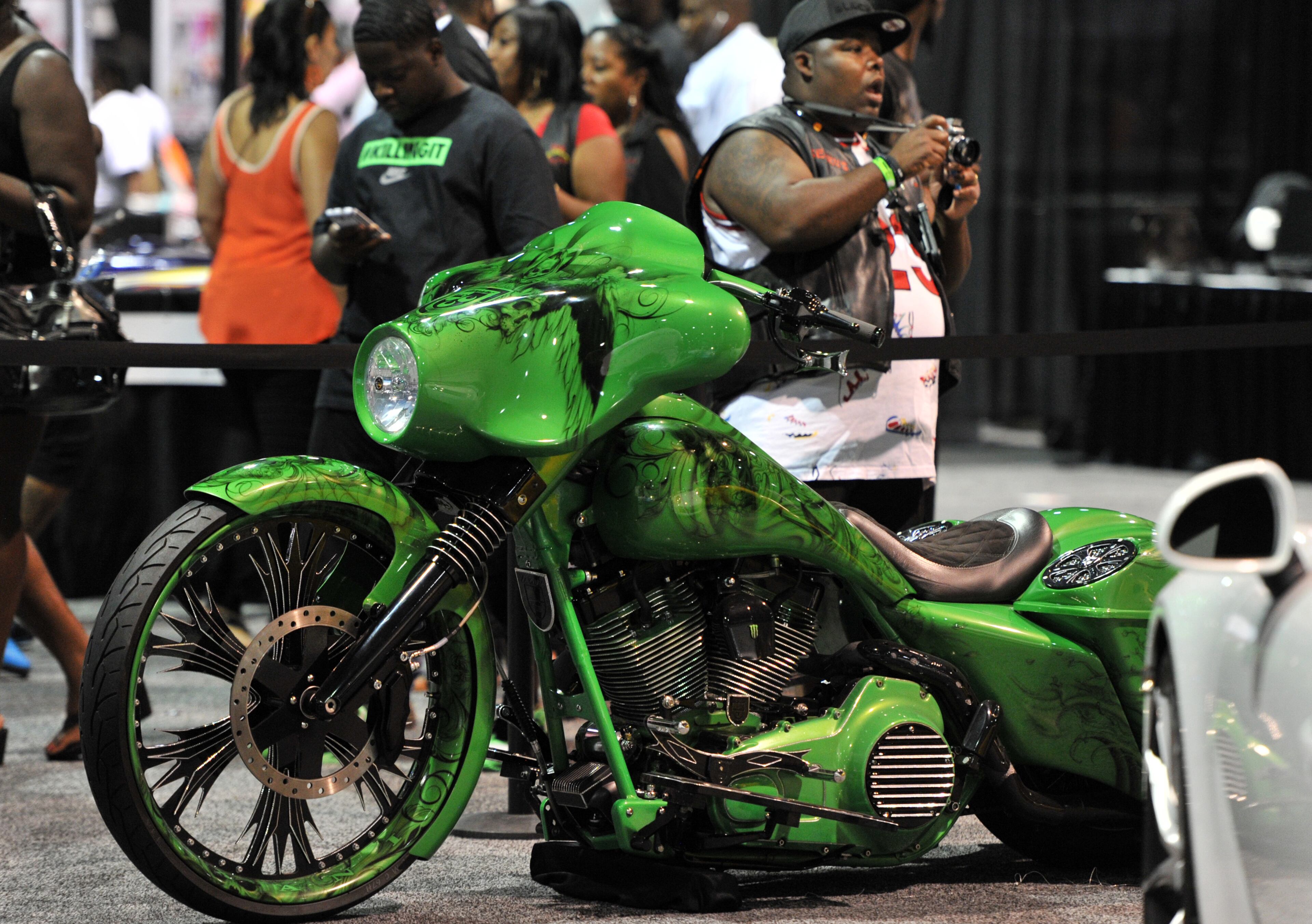 Event-goers walk by a custom motorcycle during the V-103/WAOK 10th Annual Car & Bike Show at the Georgia World Congress Center on Saturday, June 22, 2013.
