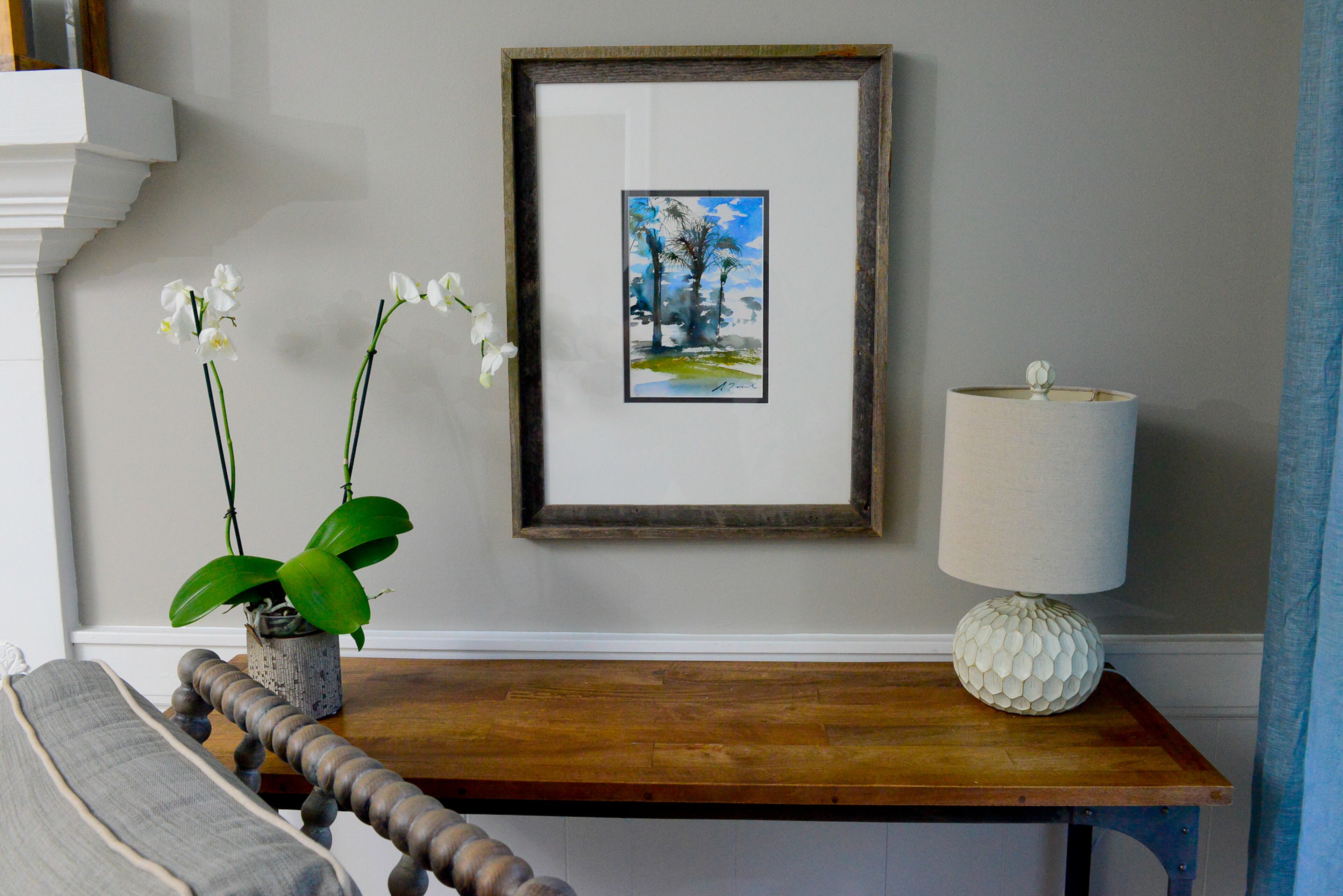 Framed watercolors fit with the calming interiors. The paintings of a palm trees and a country road - reflecting their hometowns in upstate New York and Florida - were found on Etsy.com for the homeowners.