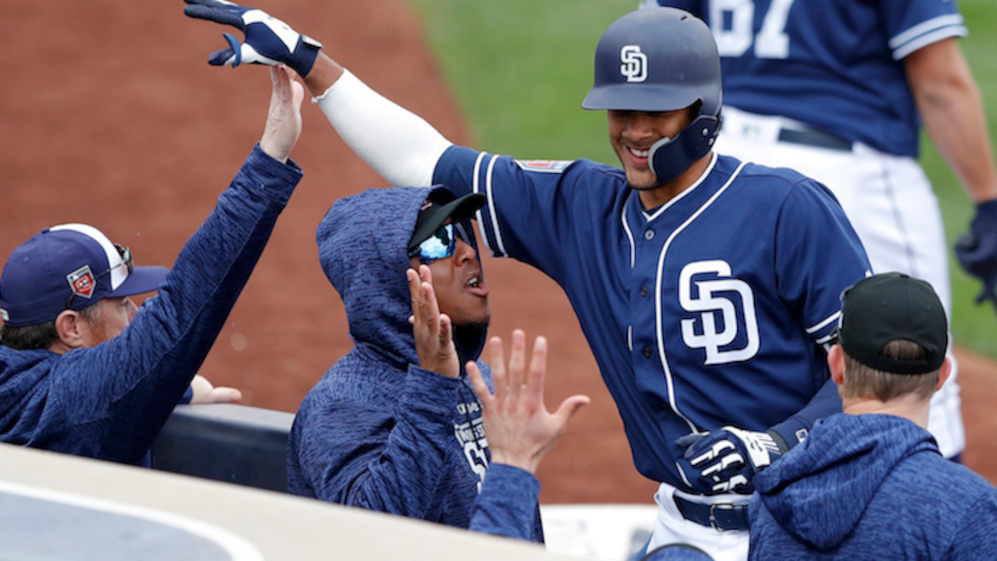 San Diego Padres shortstop Fernando Tatis, right, celebrates with teammates after hitting a home run during the eighth inning of a spring training baseball game against the Seattle Mariners, Friday, Feb. 23, 2018, in Peoria, Ariz. (AP Photo/Charlie Neibergall)