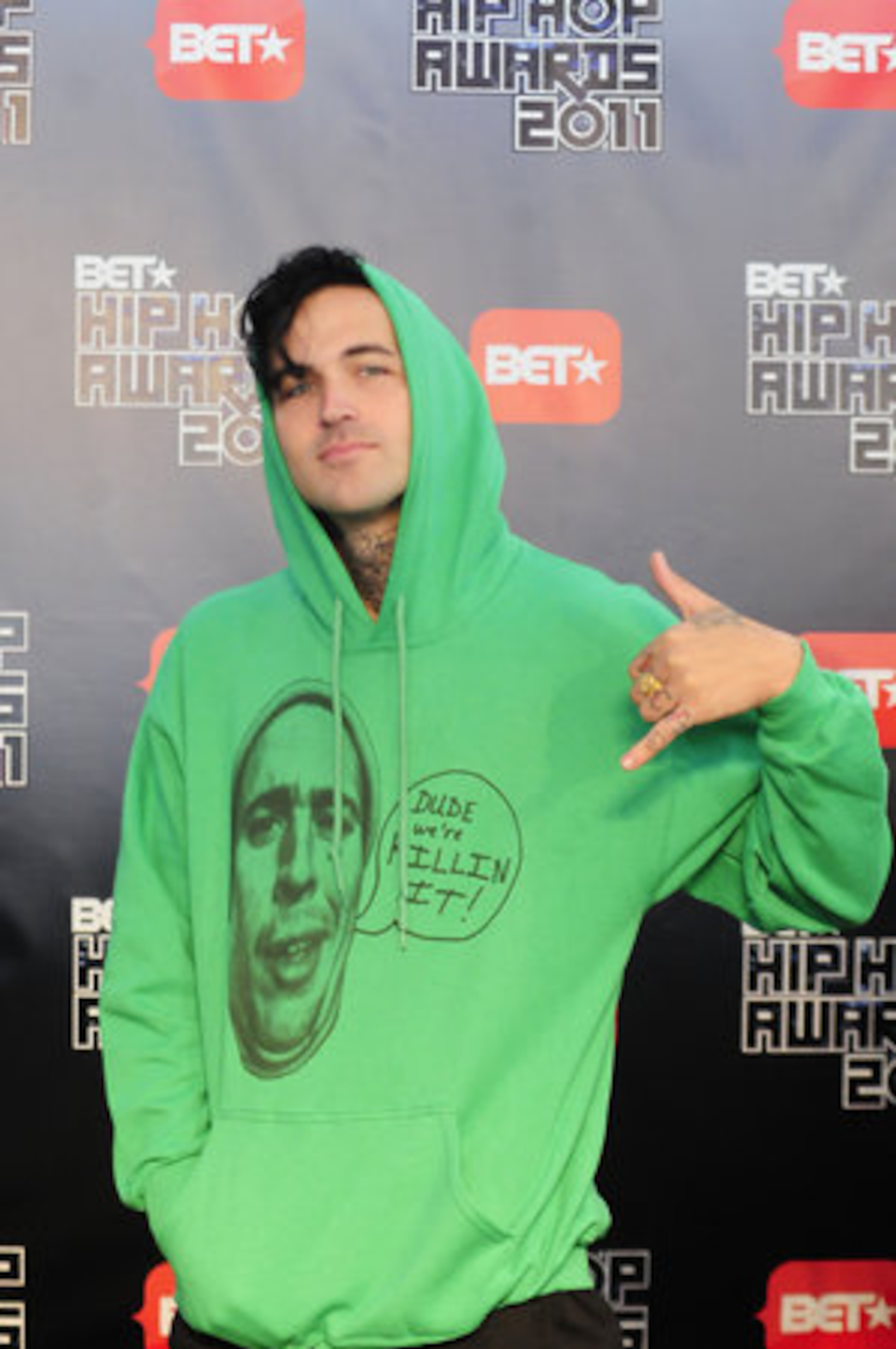 Yellawolf flashes a sign while talking to reporters.