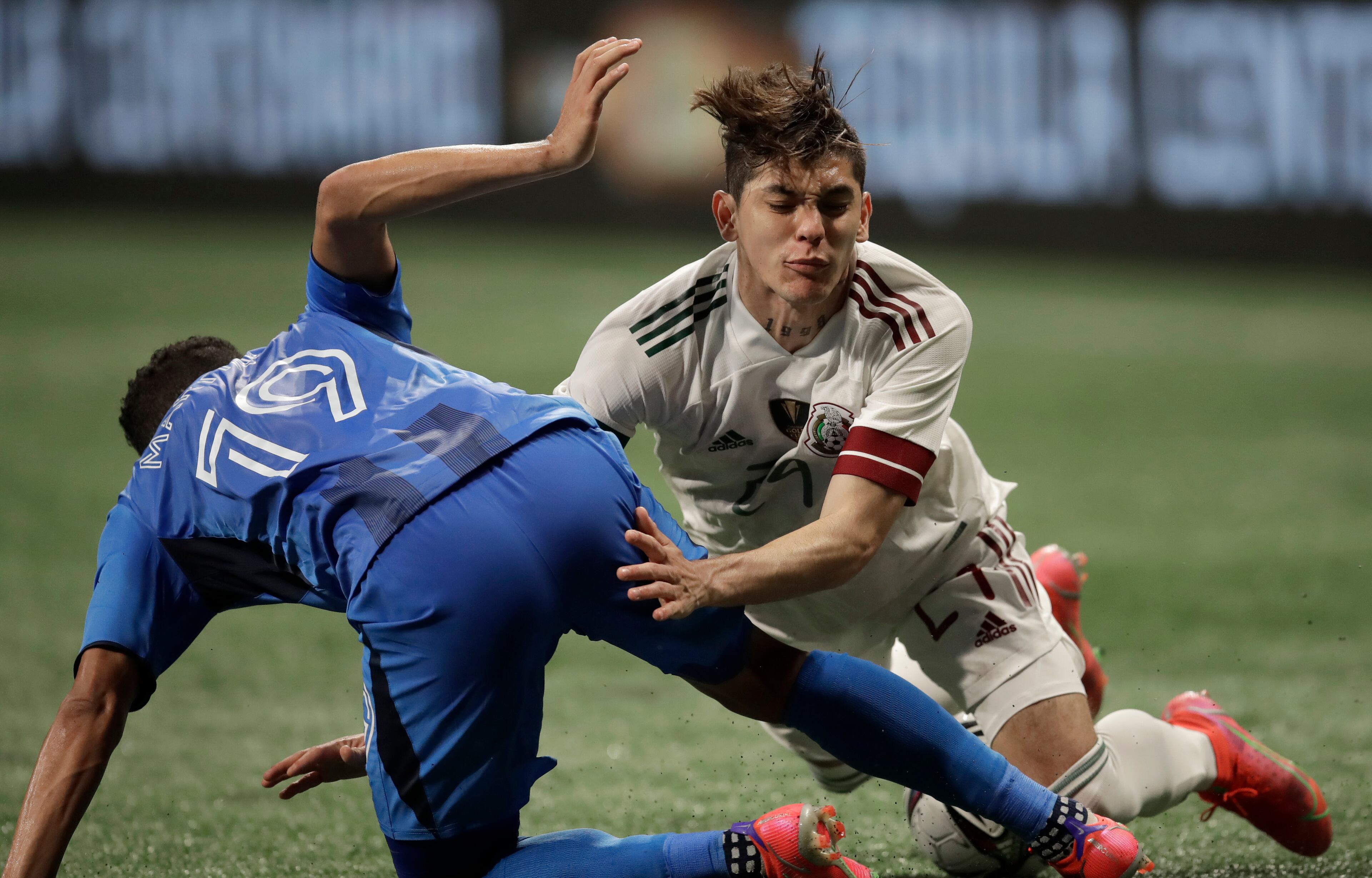 Honduras' Walter Martinez (19) collides with Mexico's Gerardo Arteaga, right, during the second half of an international friendly soccer match on Saturday, June 12, 2021, in Atlanta. (AP Photo/Ben Margot)
