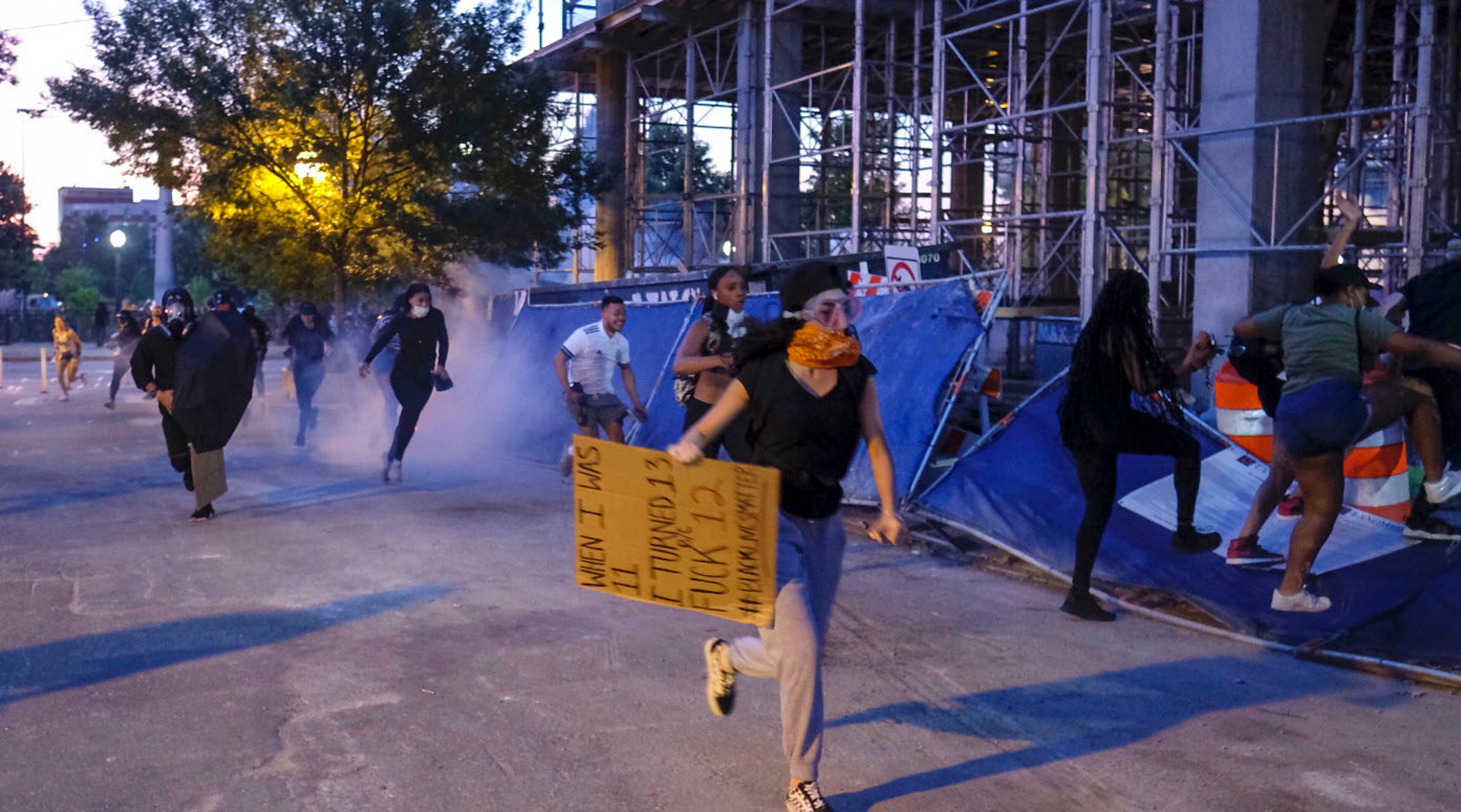 June 2, 2020 - Atlanta - Protestors dodge tear gas and police after the 9pm curfew in downtown Atlanta as protests continued for a fourth day. Protests over the death of George Floyd in Minneapolis police custody continued around the United States, as his case renewed anger about others involving African Americans, police and race relations. Ben Gray for the Atlanta Journal Constitution