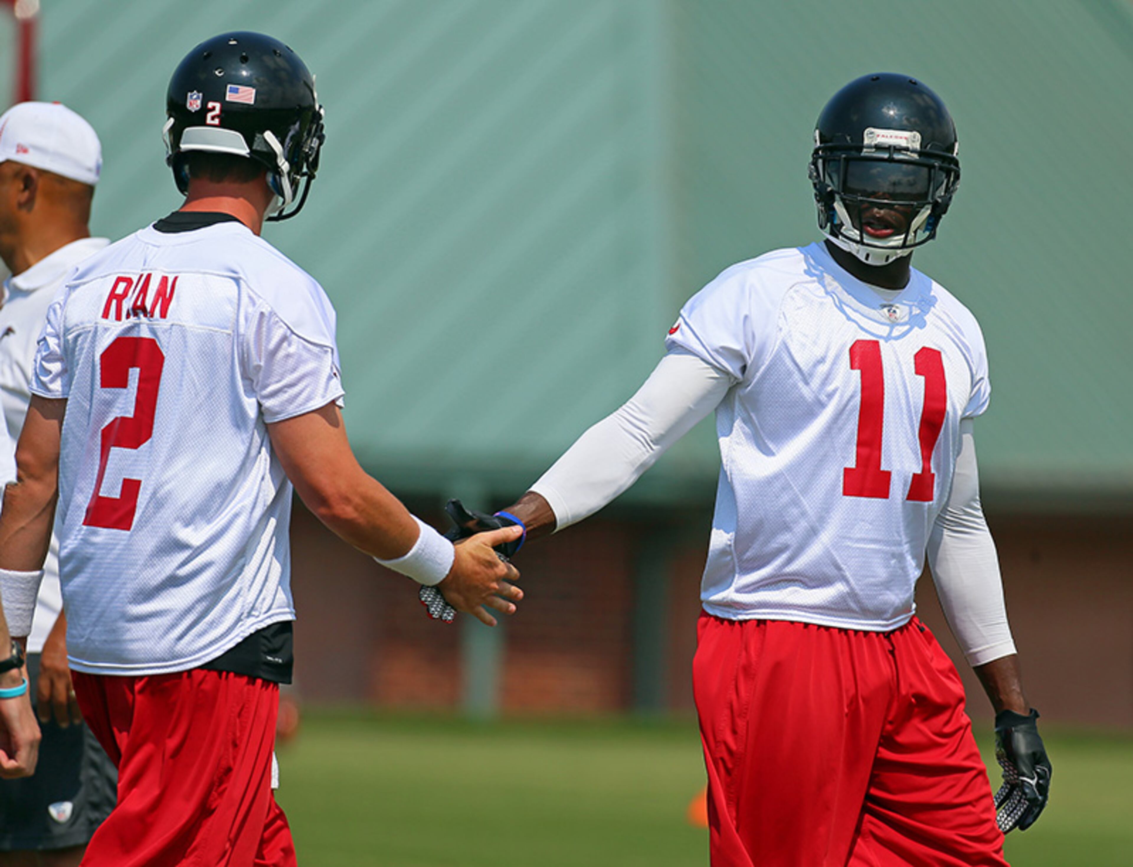 Matt Ryan gives wide receiver Julio Jones high-five after he caught a pass on an offensive play during team practice.