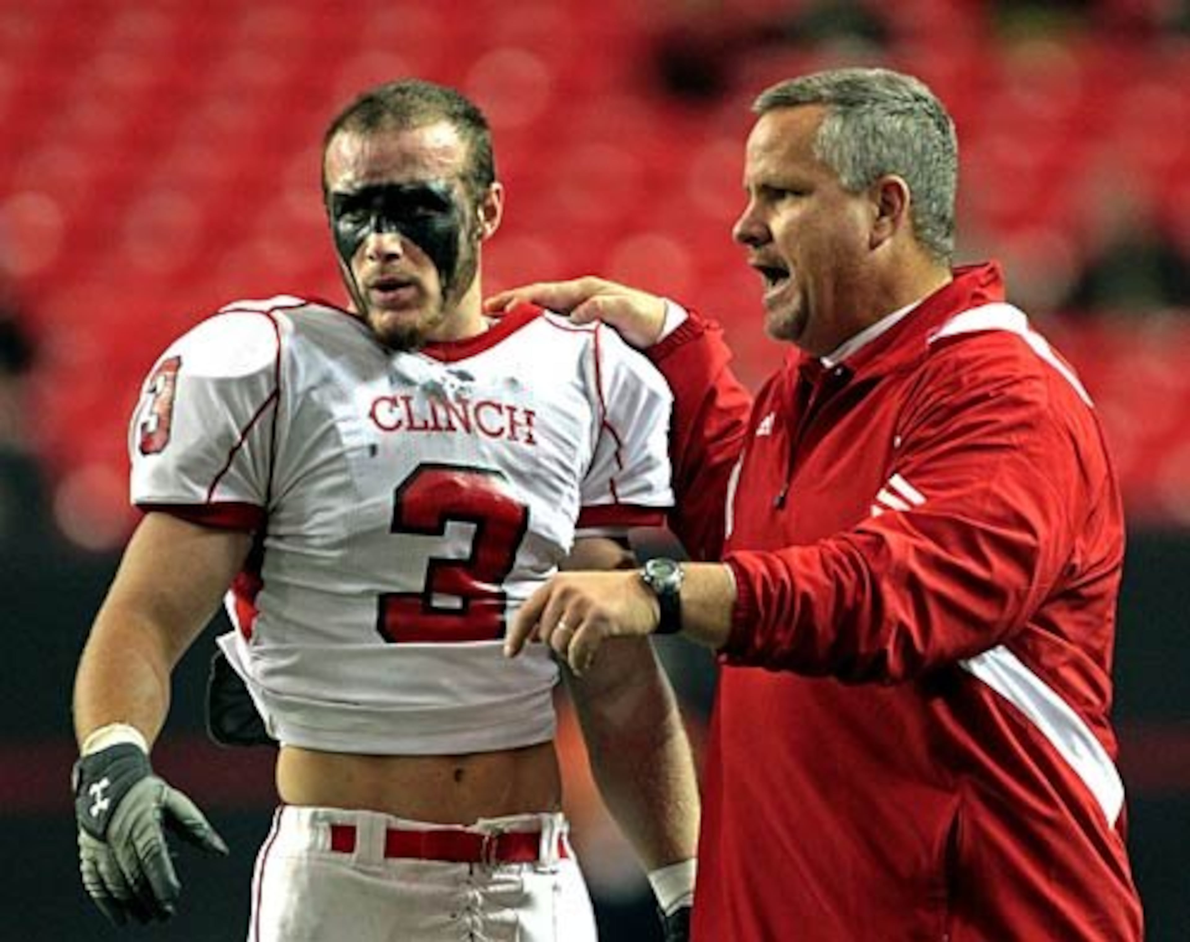 Clinch County coach Jim Dickerson (right), shown speaking with Dalton Bennett, won five state titles — the most of any county-school coach this century. (Jason Getz/2010)