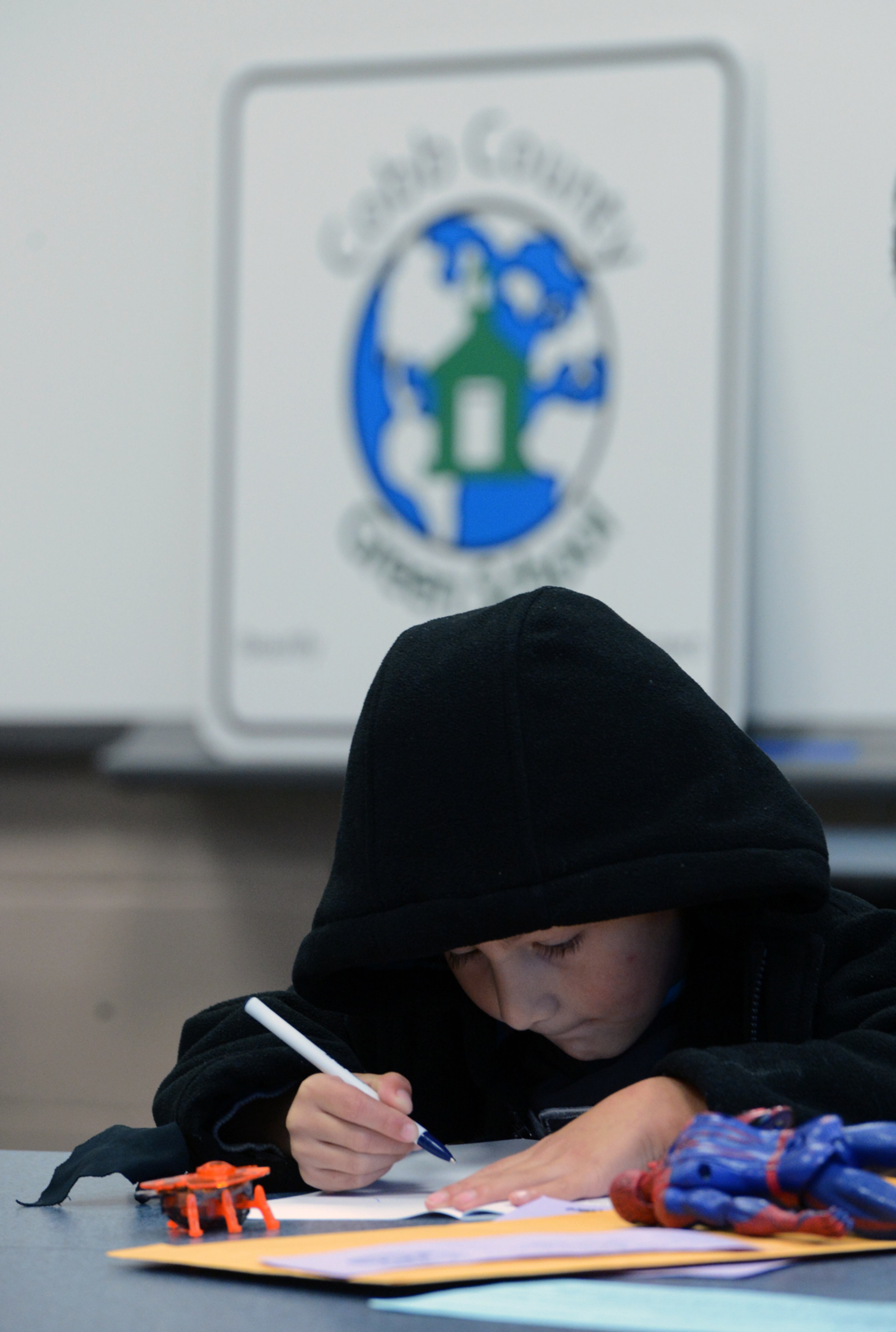 Randy Perez draws with a marker as his mother registers him for kindergarten at Mableton Elementary School on Wednesday, March 27, 2013. Today was his fifth birthday. Cobb County elementary schools began registering all new kindergarten students for the upcoming 2013-14 school year on today from 8:00 a.m. - 11:30 a.m. Georgia law requires that kindergarten students be five years old on or before September 1st and first grade students must be six years old on or before September 1st to be registered.