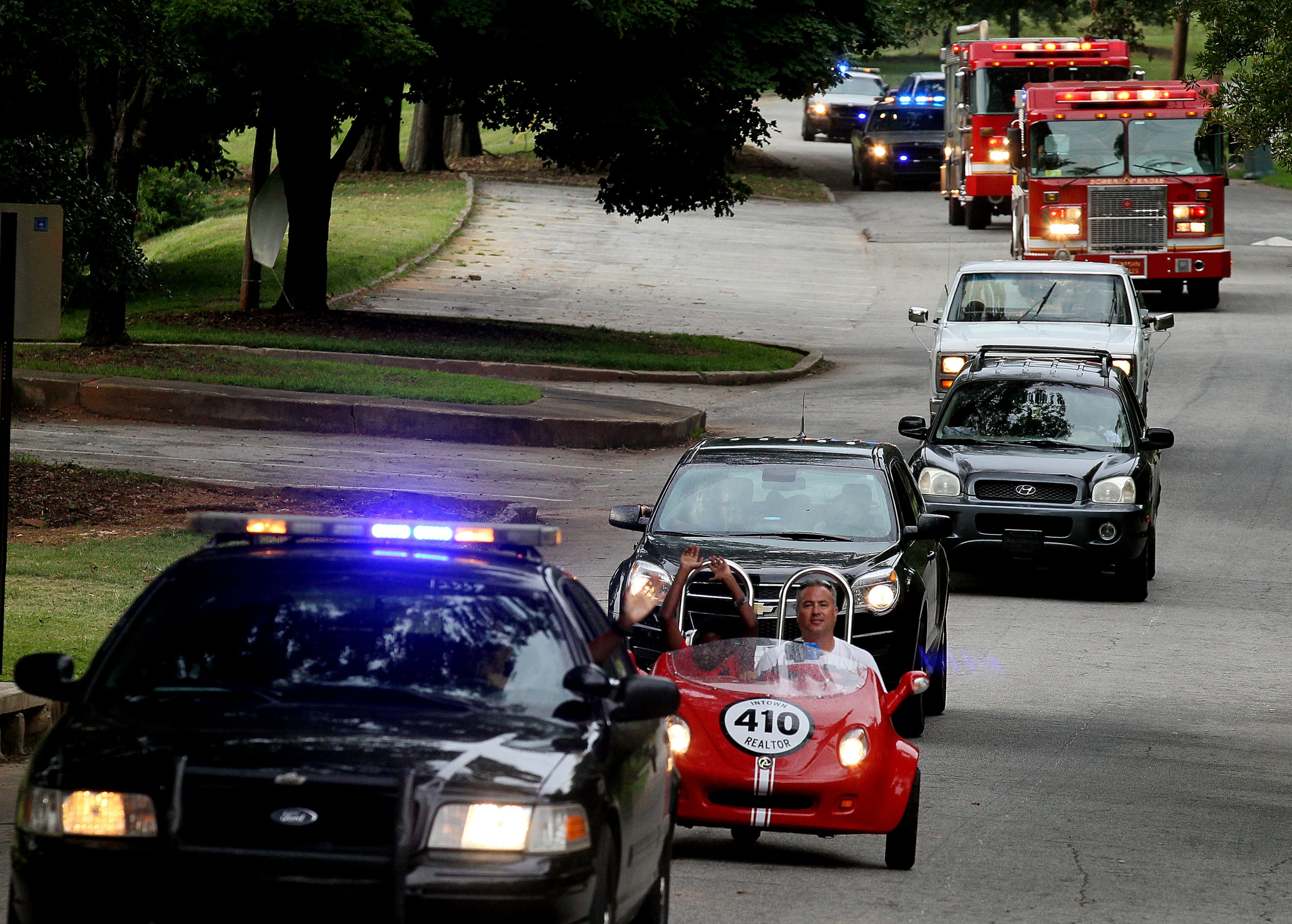 Police cars & fire engines joined private cars for a neighborhood parade at the Parkview Community Recreational Center in Atlanta during the 30th anniversary of National Night Out on Tuesday.
