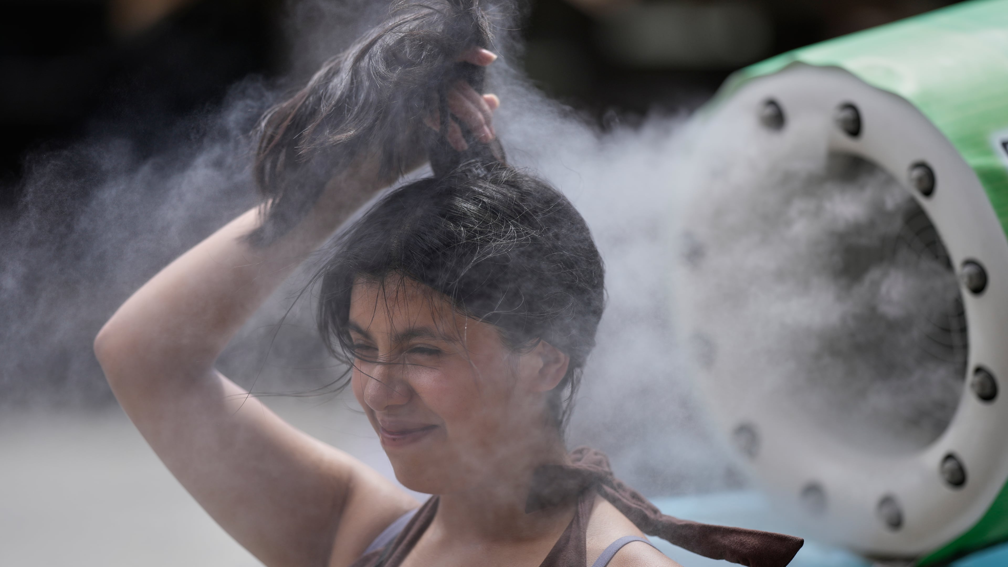 FILE - A person cools off at a cooling mist spot on a hot and sunny day at the Sensoji Buddhist temple in Tokyo's Asakusa district on Aug. 7, 2026. (AP Photo/Eugene Hoshiko, File)