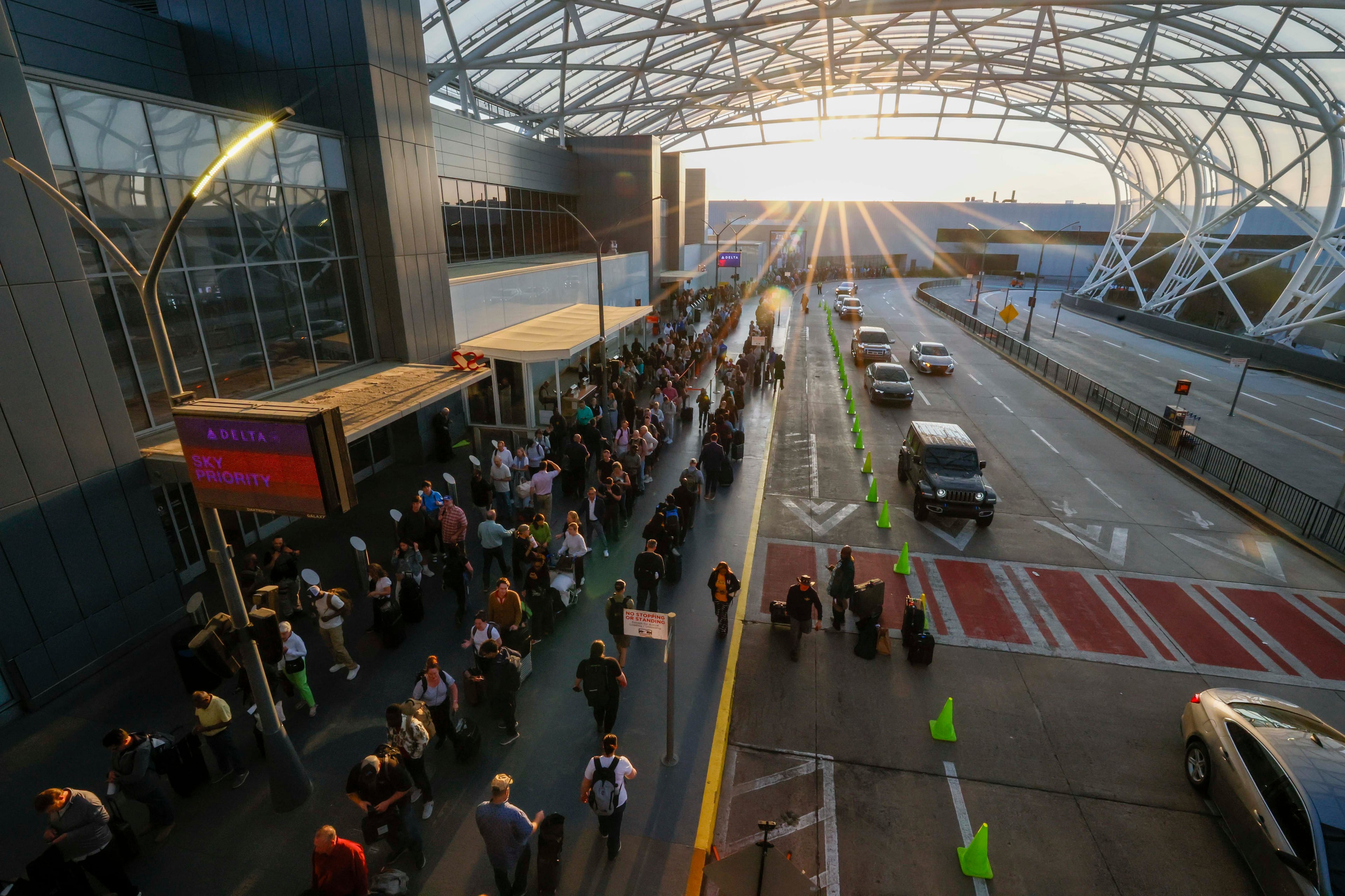 Travelers line up all the way to the end and circle back on the sidewalks for TSA security checks early Monday morning at the domestic terminal of Hartsfield-Jackson Atlanta International Airport on March 23, 2026. TSA officers have been working without pay for weeks during the partial government shutdown. (Miguel Martinez/AJC)