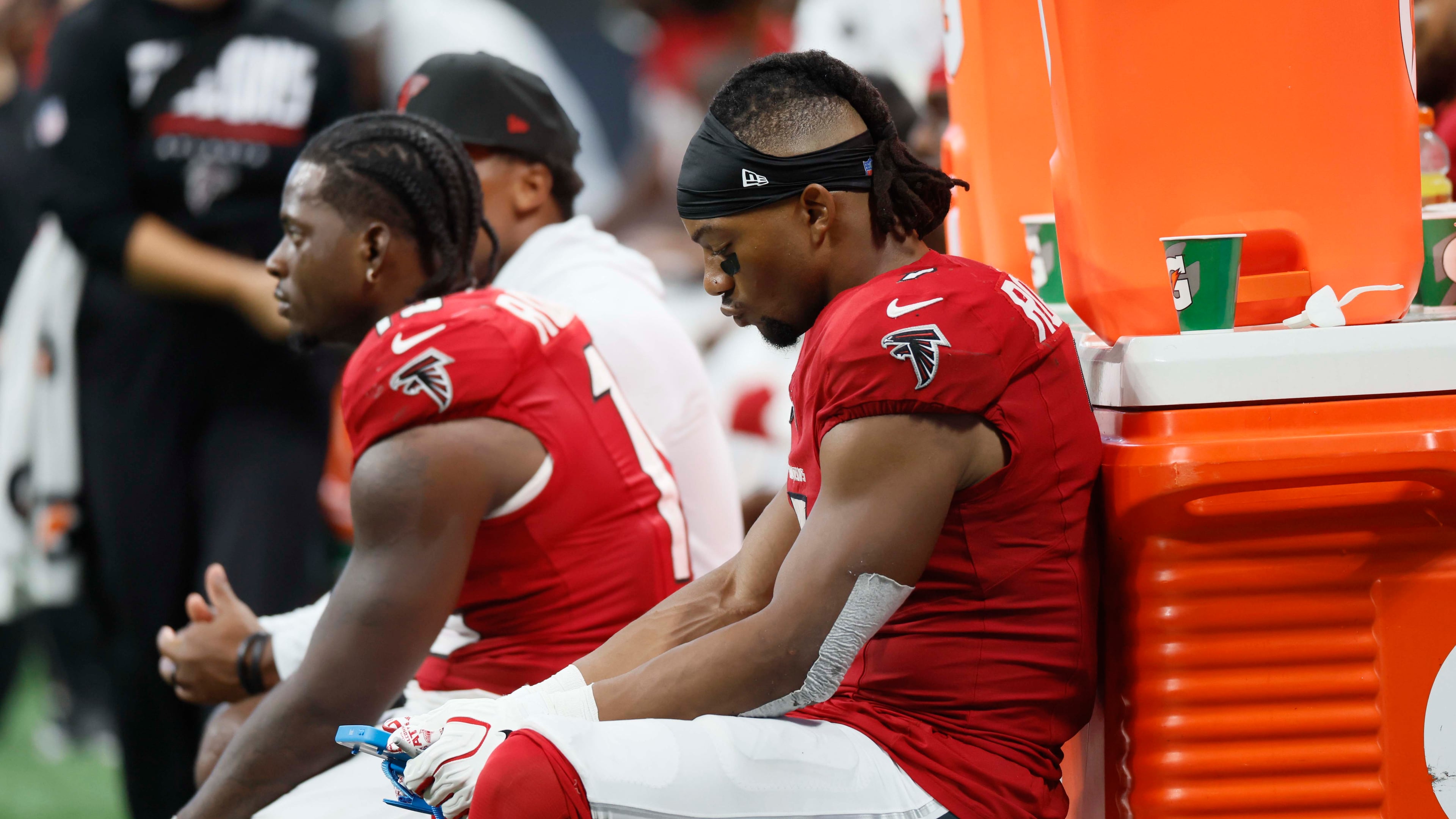 Running back Bijan Robinson (right) and other Falcons players sit on the bench during the second half of a blowout against the Panthers on Sunday, Sept. 20, 2026, at Mercedes-Benz Stadium in Atlanta. (Miguel Martinez/AJC)
