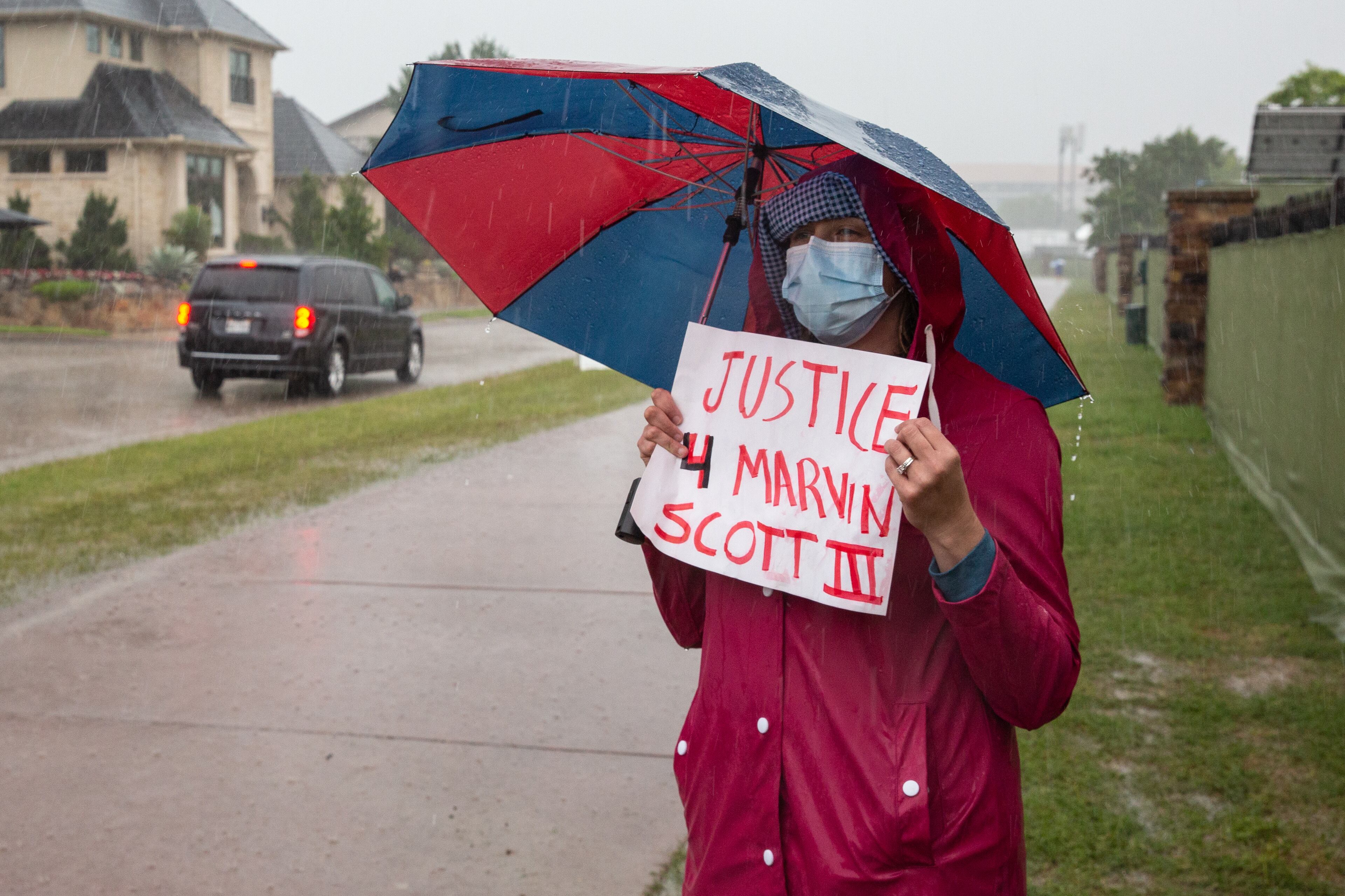 Elizabeth Michel holds her sign toward spectators of the Byron Nelson PGA golf tournament passing by at TPC Craig Ranch in McKinney, Texas. Michel and a group of demonstrators gathered at the entrance to spread awareness of the death of Marvin Scott III. (Shelby Tauber/The Dallas Morning News/TNS)