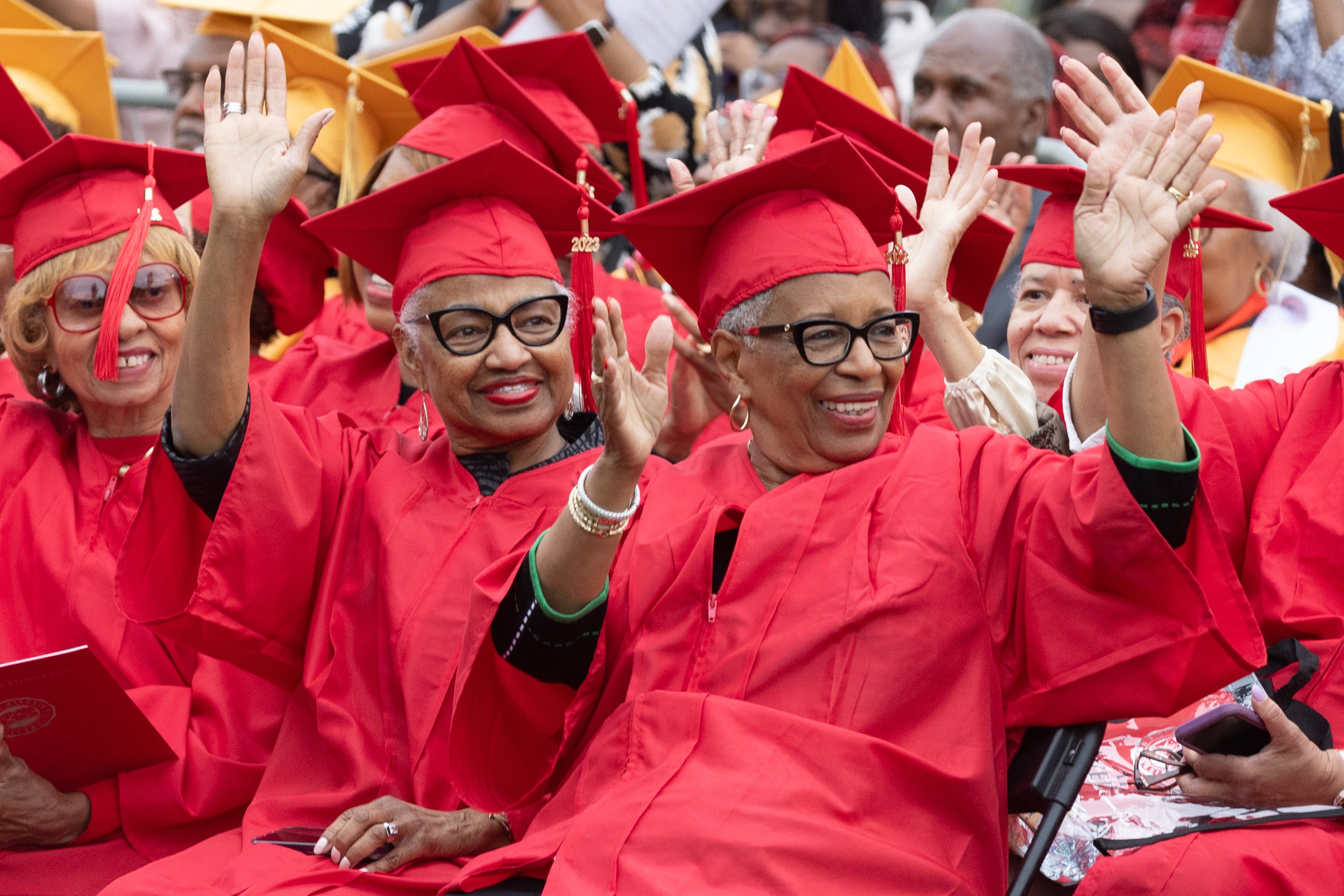 Past graduates wave as they are introduced during the Clark Atlanta University commencement ceremony in Panther Stadium on Saturday, May 20, 2023. (Steve Schaefer / steve.schaefer@ajc.com)