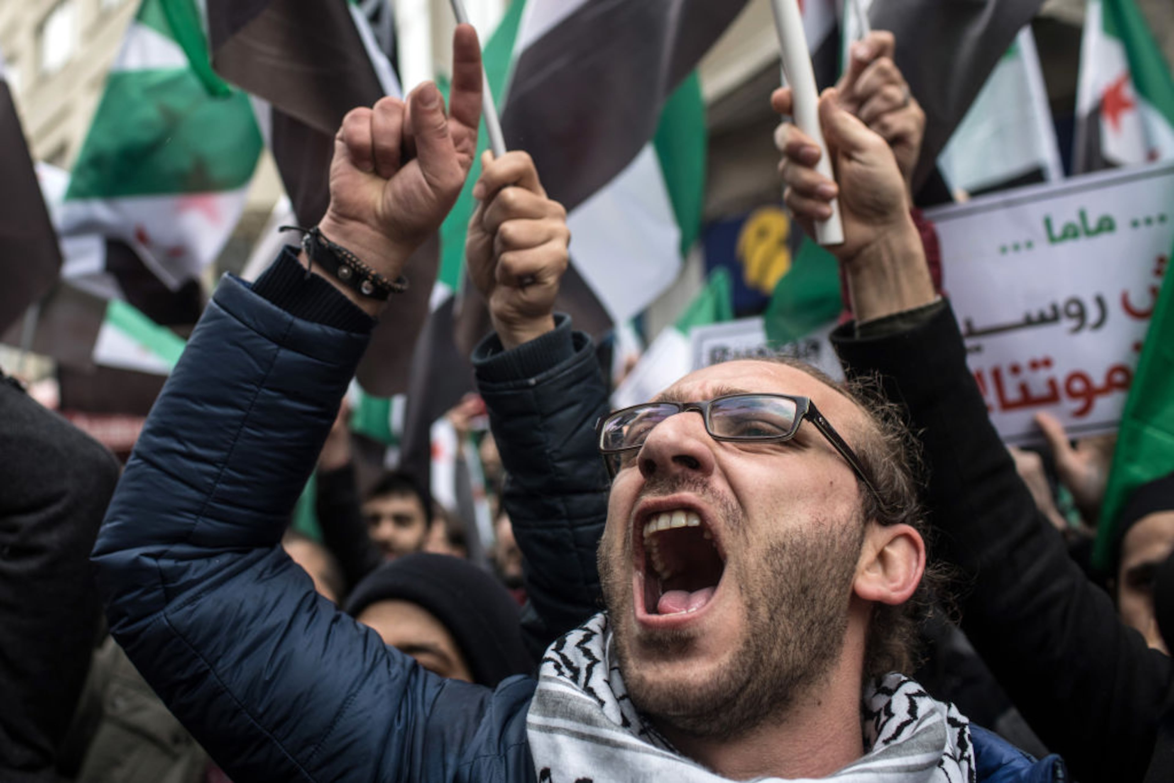 ISTANBUL, TURKEY - FEBRUARY 22: People hold signs and chant slogans during a protest against the Russian and Syrian forces bombing and blockade of the Syrian enclave of Eastern Ghouta, outside the Russian Consulate on February, 22, 2018 in Istanbul, Turkey. Syrian forces supported by Russian warplanes have continued to bomb the suburb over the past three days bring the civilian death toll to more than 270. Since early February the UN has recorded 346 civilian deaths and 878 wounded mostly from airstrikes. Russia has denied any involvement in the airstrikes. (Photo by Chris McGrath/Getty Images)
