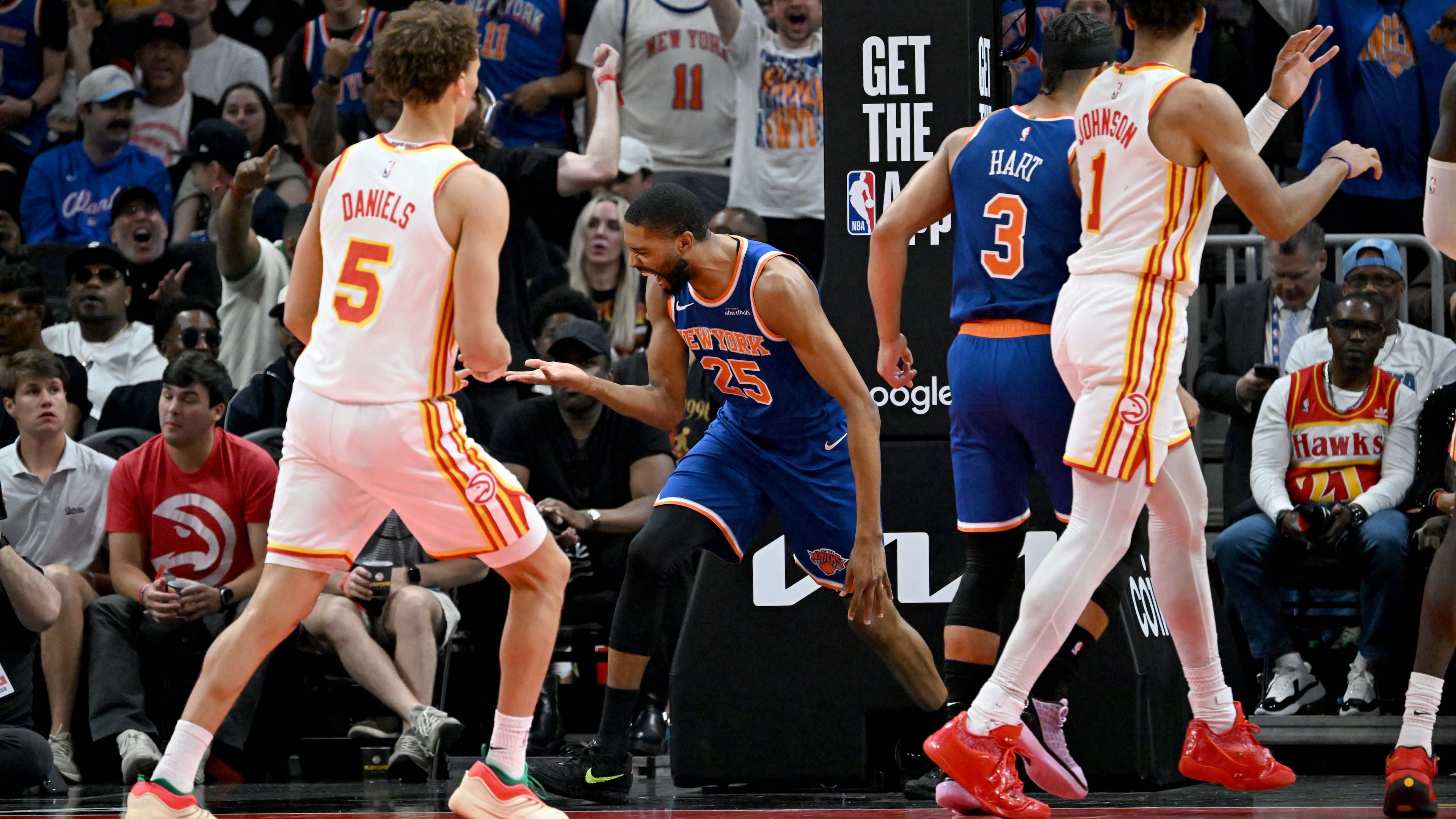 Knicks guard Mikal Bridges (center), flanked by the Hawks’ Dyson Daniels (left) and Jalen Johnson, celebrates after dunking the ball during Game 6 of the first-round Eastern Conference series at State Farm Arena on Thursday, April 30, 2026, in Atlanta. (Hyosub Shin/AJC)