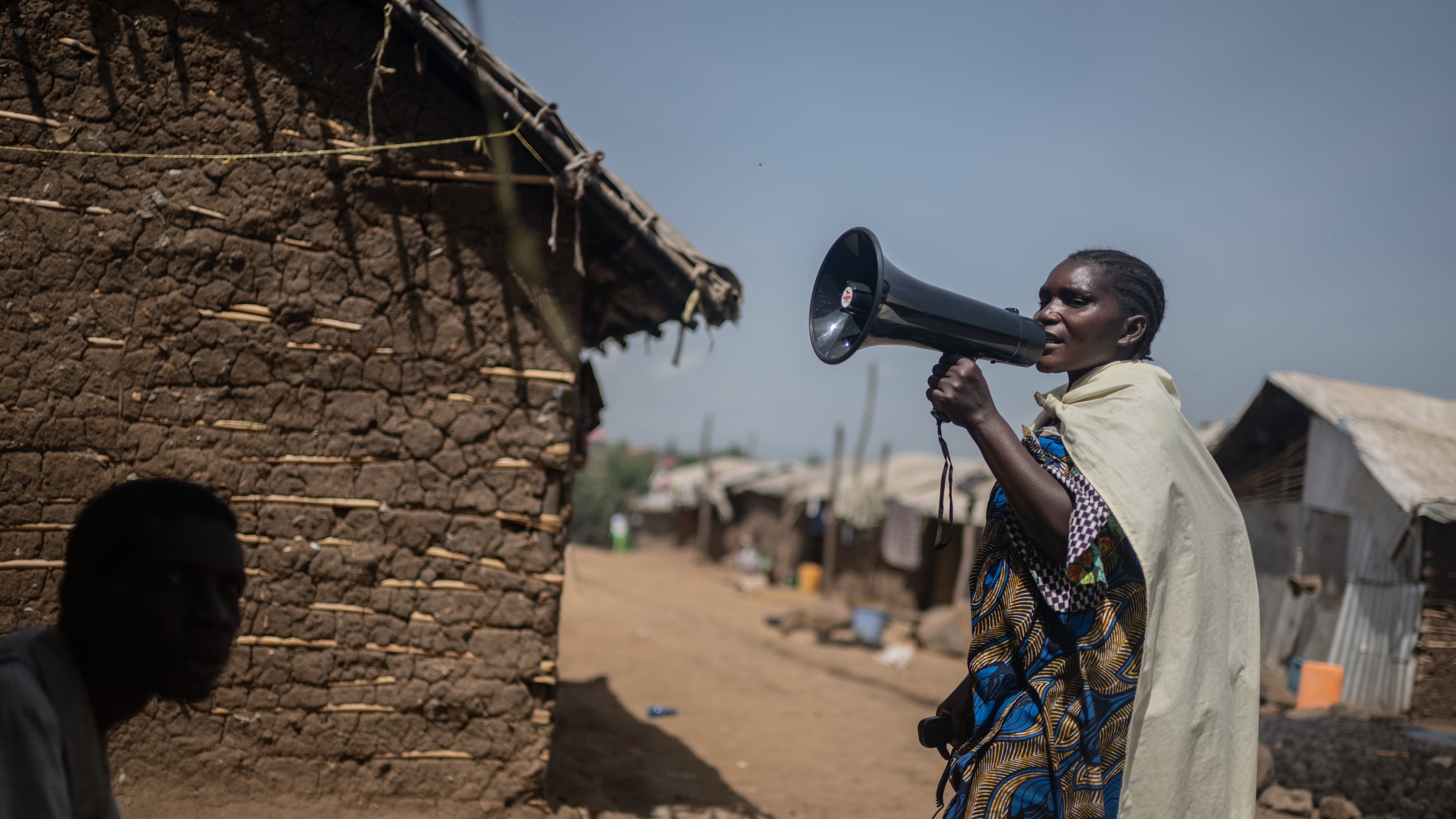 Machozi Naumi, 45, raises awareness of Ebola in the camp on the property of the city's ISP (Institut Supérieur Pédagogique), where internally displaced people reside in Bunia, Congo, Tuesday, May 26, 2026. (AP Photo/Moses Sawasawa)