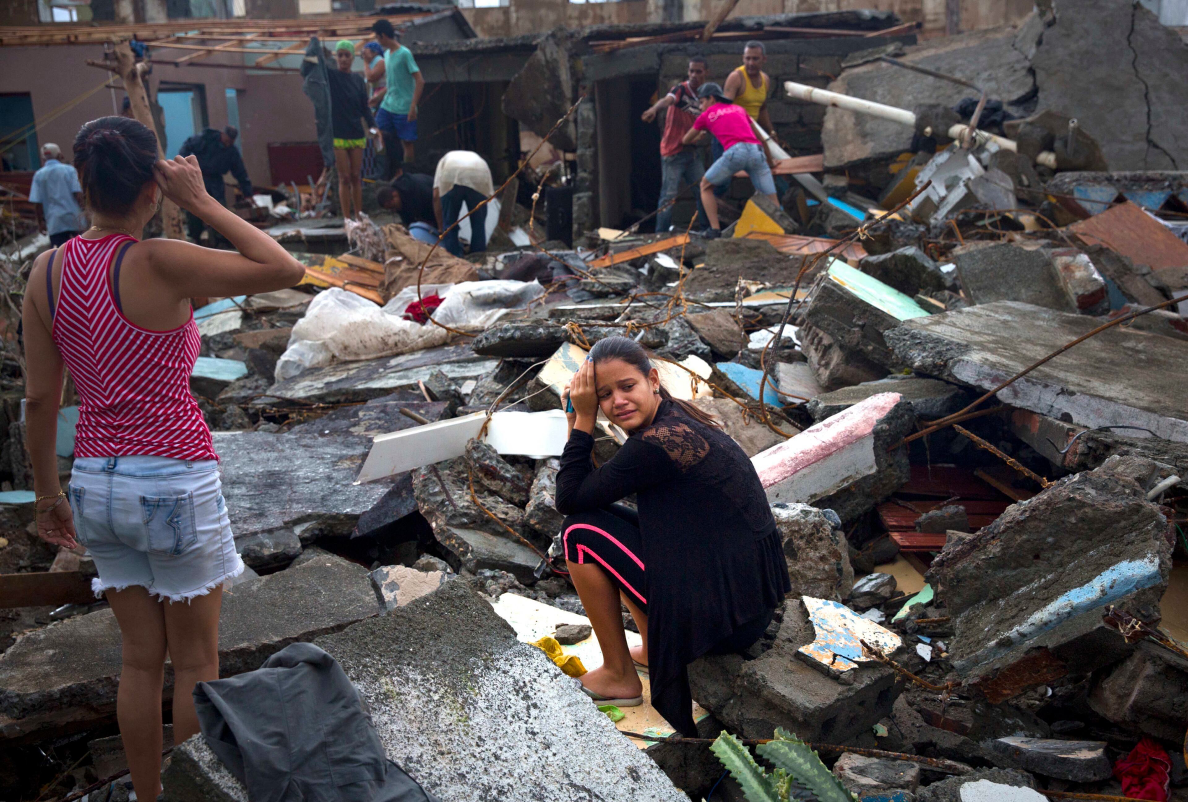 A woman cries amid the rubble of her home, destroyed by Hurricane Matthew in Baracoa, Cuba, Wednesday, Oct. 5, 2016. The hurricane rolled across the sparsely populated tip of Cuba overnight, destroying dozens of homes in Cuba's easternmost city, Baracoa, leaving hundreds of others damaged. (AP Photo/Ramon Espinosa)
