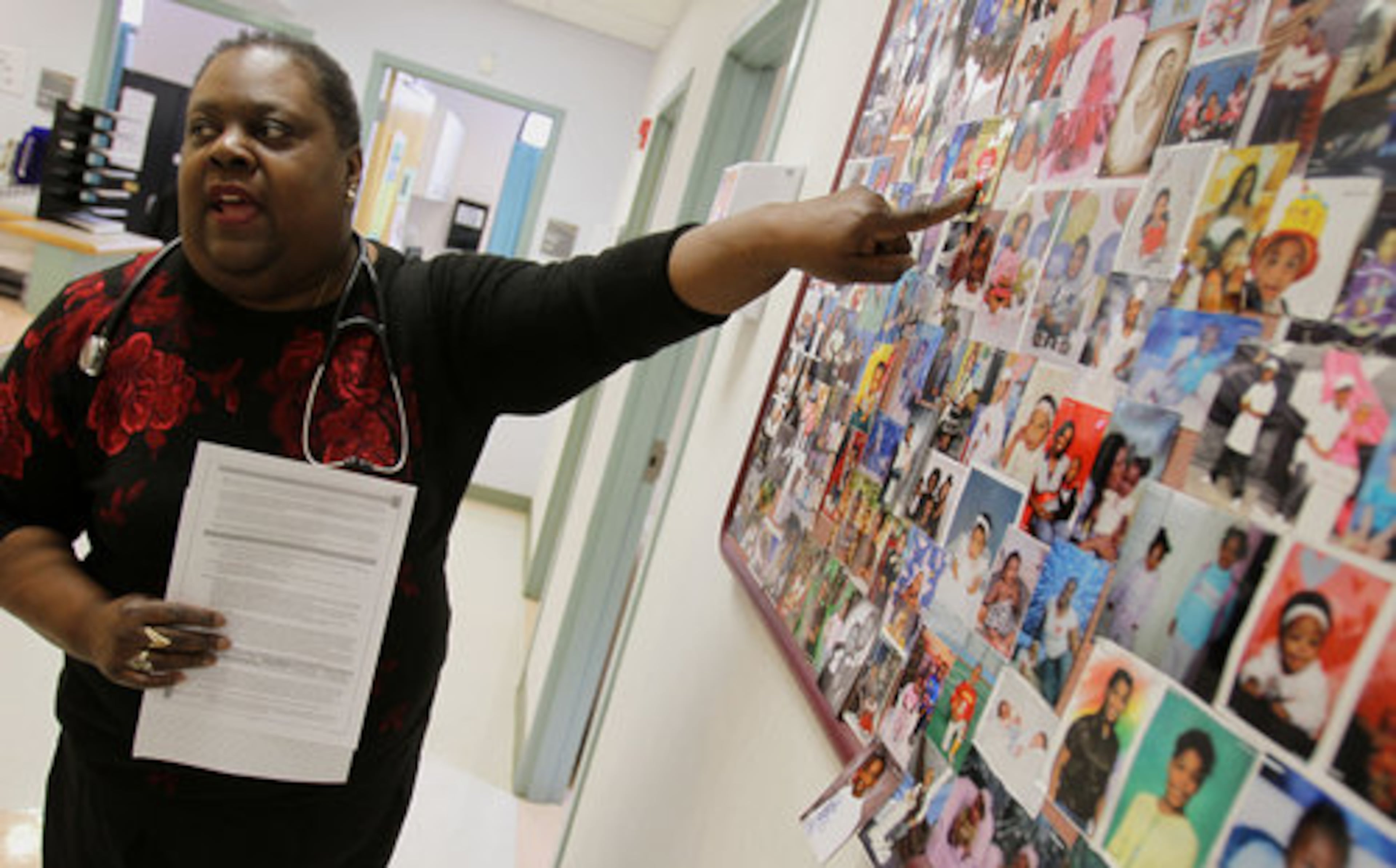 Dr. Melba Johnson points to pictures of patients that Otis W. Smith Health Center has served. "We have a good relationship with all the families that come here, " she says. Dr. Johnson has been at the center for the last 13 years.