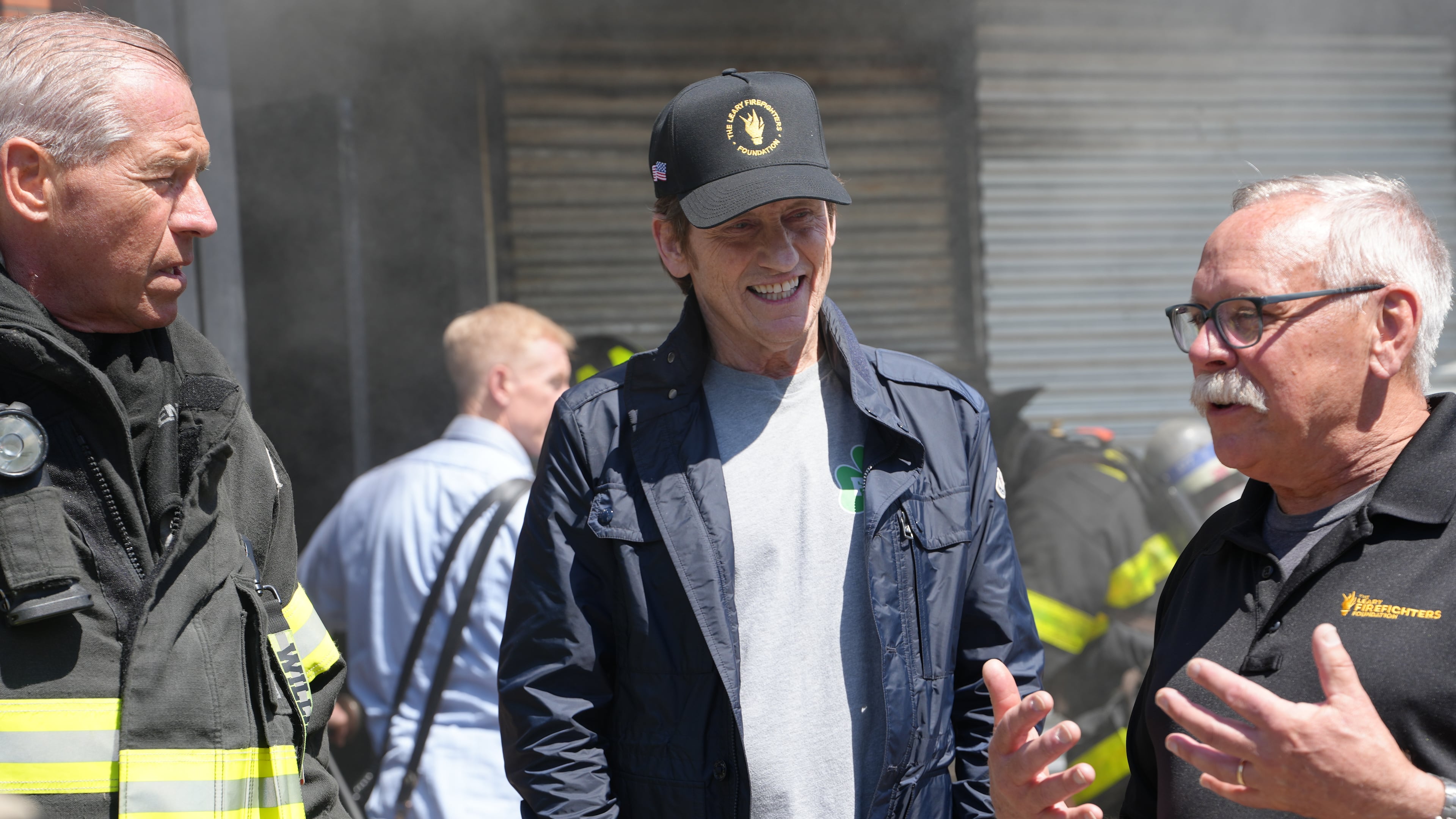 This image provided by Grand Street Media for The Leary Firefighters Foundation shows Leary Firefighters Foundation founder Denis Leary, center, talking with members of the foundation's board of directors, Brian Williams, left, and David Morkal, right, at the 2026 Denis Leary FDNY Firefighter Challenge in New York on May 1, 2026. (Jesse Guma/Grand Street Media for The Leary Firefighters Foundation via AP)
