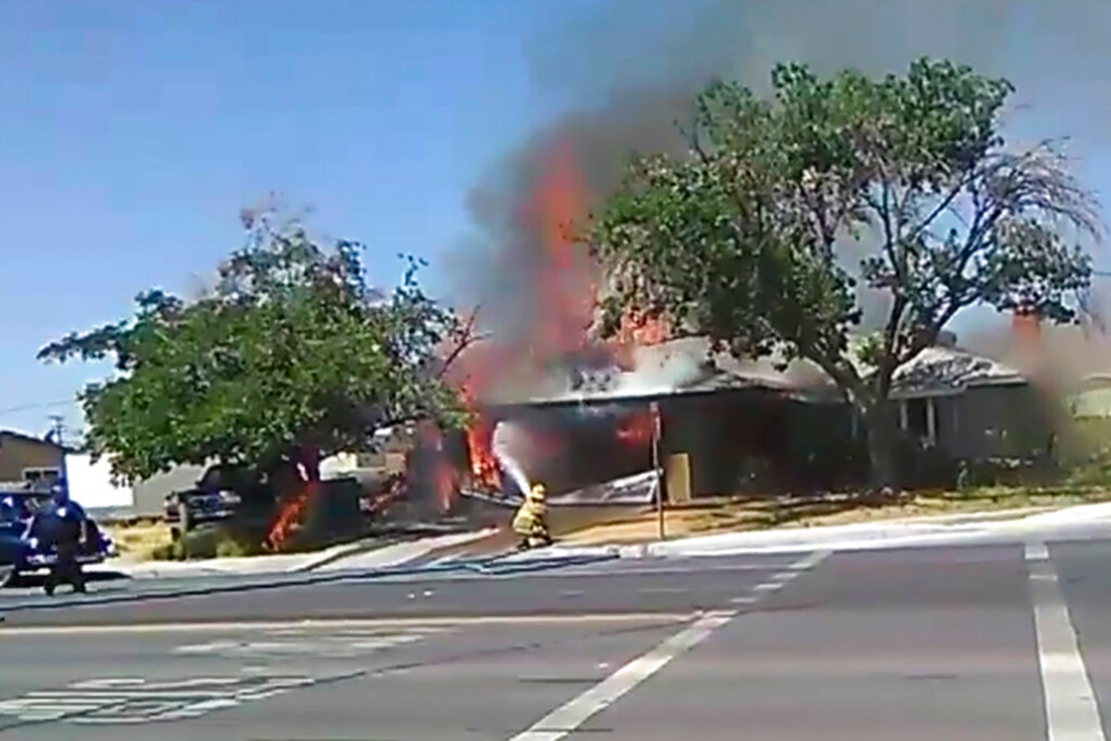 In this image taken from video provided by Ben Hood, a firefighter works to extinguish a fire, Thursday, July 4, 2019, following an earthquake in Ridgecrest, Calif.