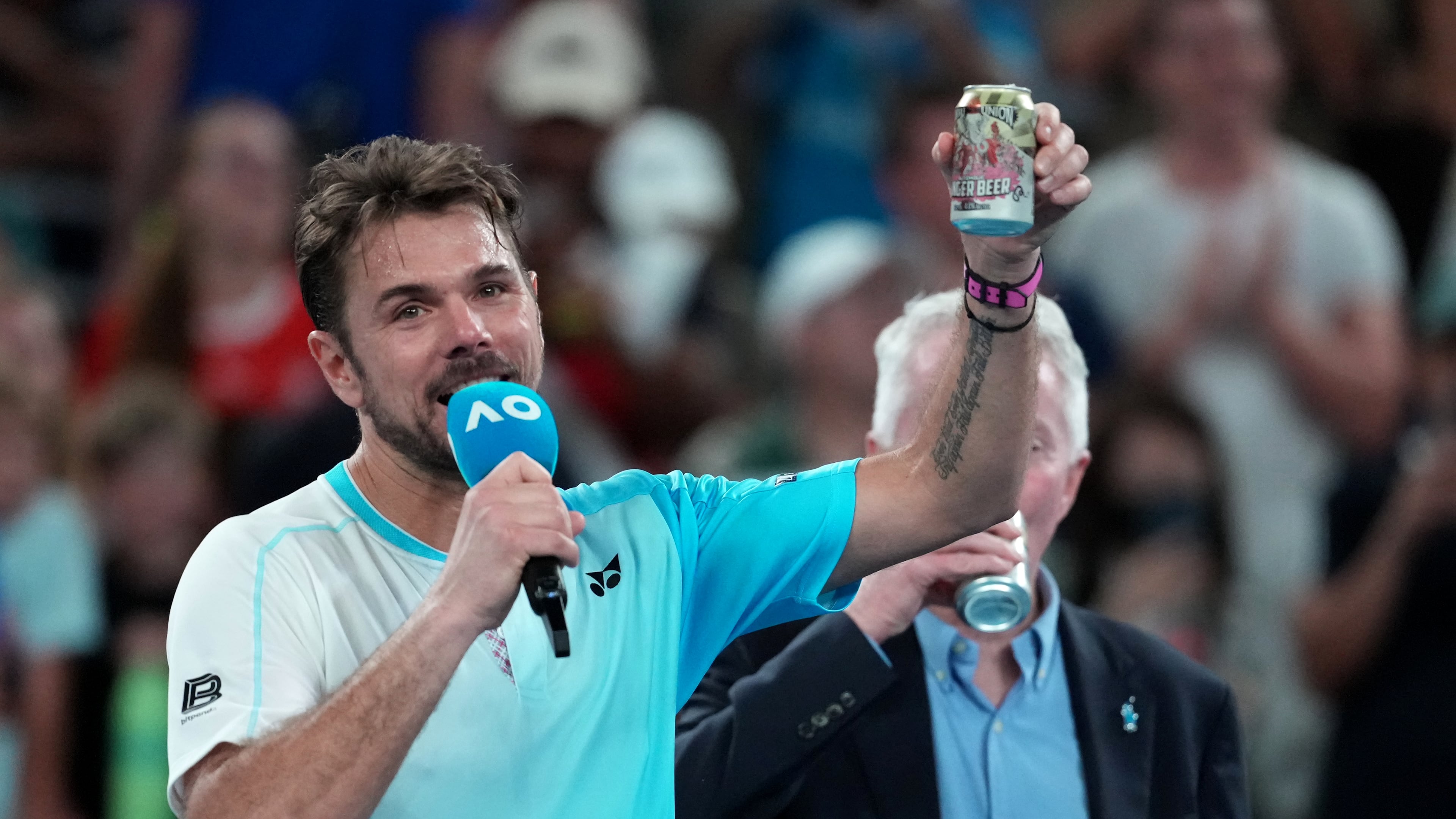 Stan Wawrinka of Switzerland holds up a beer following his third round loss to Taylor Fritz of the U.S. at the Australian Open tennis championship in Melbourne, Australia, Saturday, Jan. 24, 2026. (AP Photo/Asanka Brendon Ratnayake)