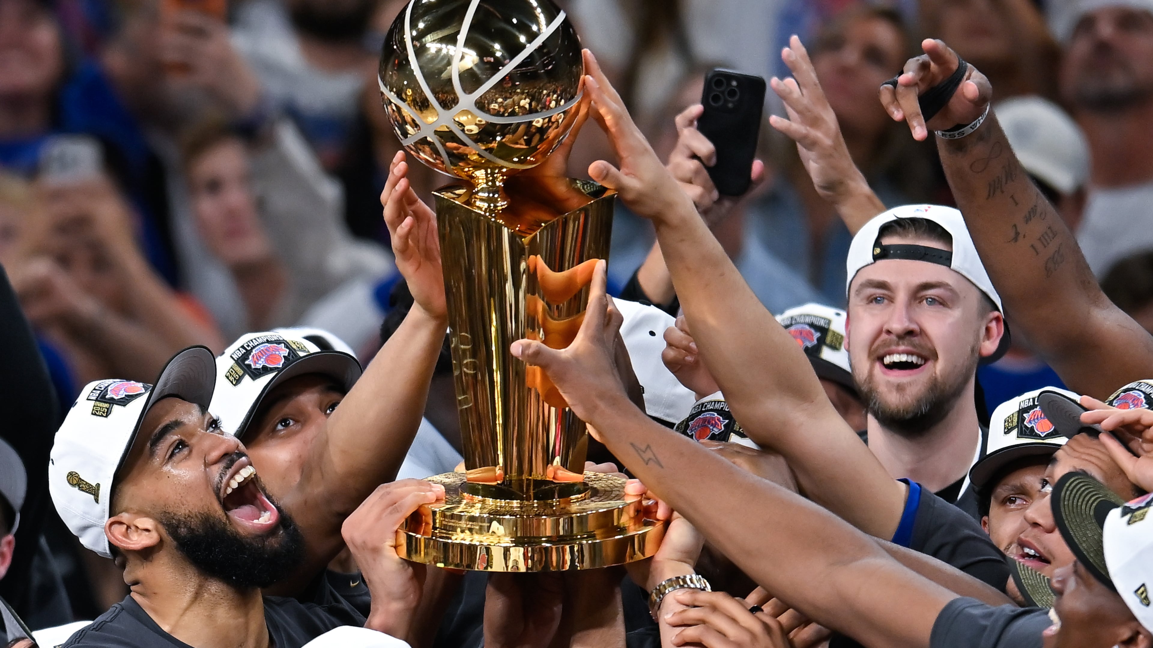 The New York Knicks celebrate with the Larry O'Brien Championship Trophy after defeating the San Antonio Spurs in Game 5 of the NBA Finals basketball series, Saturday, June 13, 2026, in San Antonio. (AP Photo/Darren Abate)