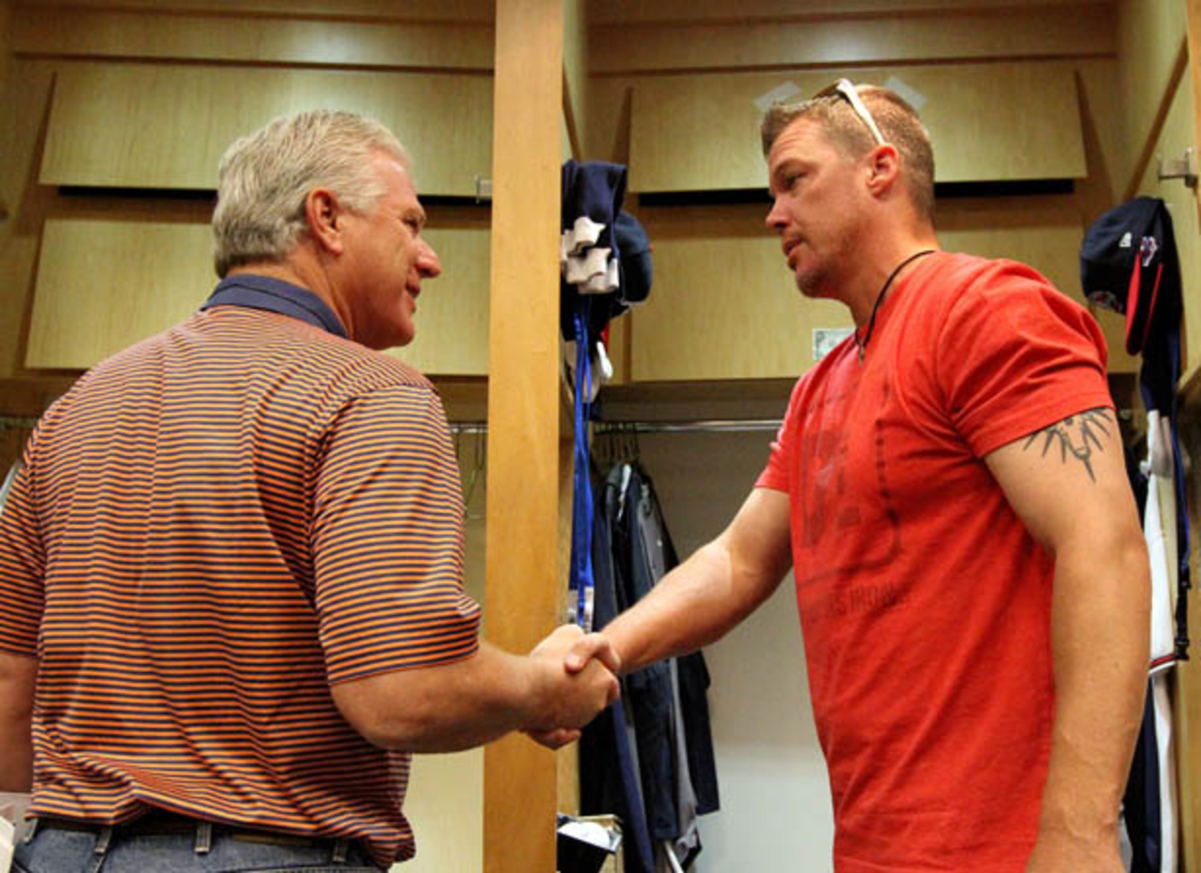 Braves general manager Frank Wren (left) shakes retiring third baseman Chipper Jones's hand as he cleans out his locker at Turner Stadium in Atlanta on Saturday. Their 6-3 loss to the Cardinals ended their season and Chipper's almost two-decade career with the Braves.