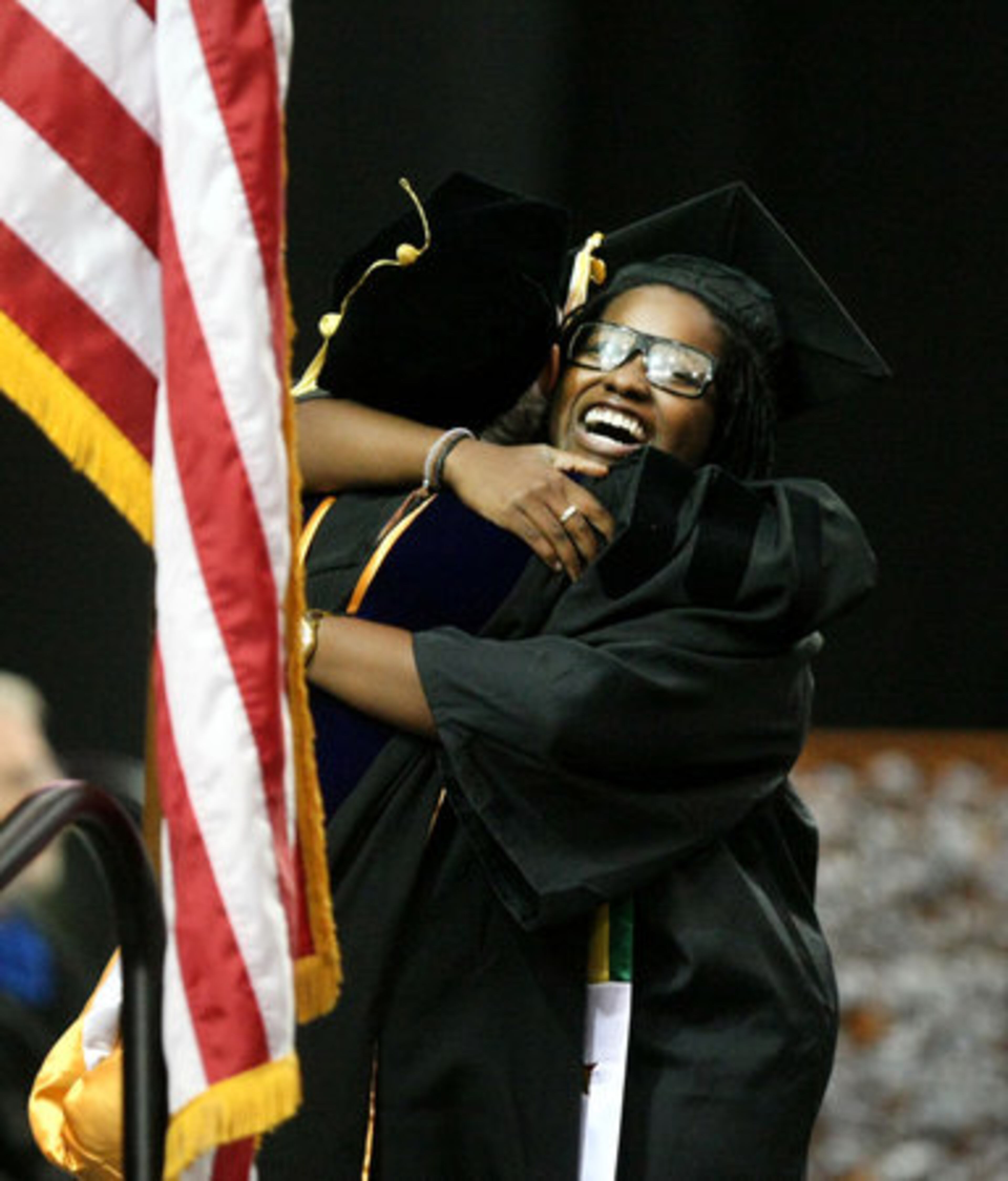 Rita Mucauele (left), high-fives a fellow graduate as they walk off the stage.