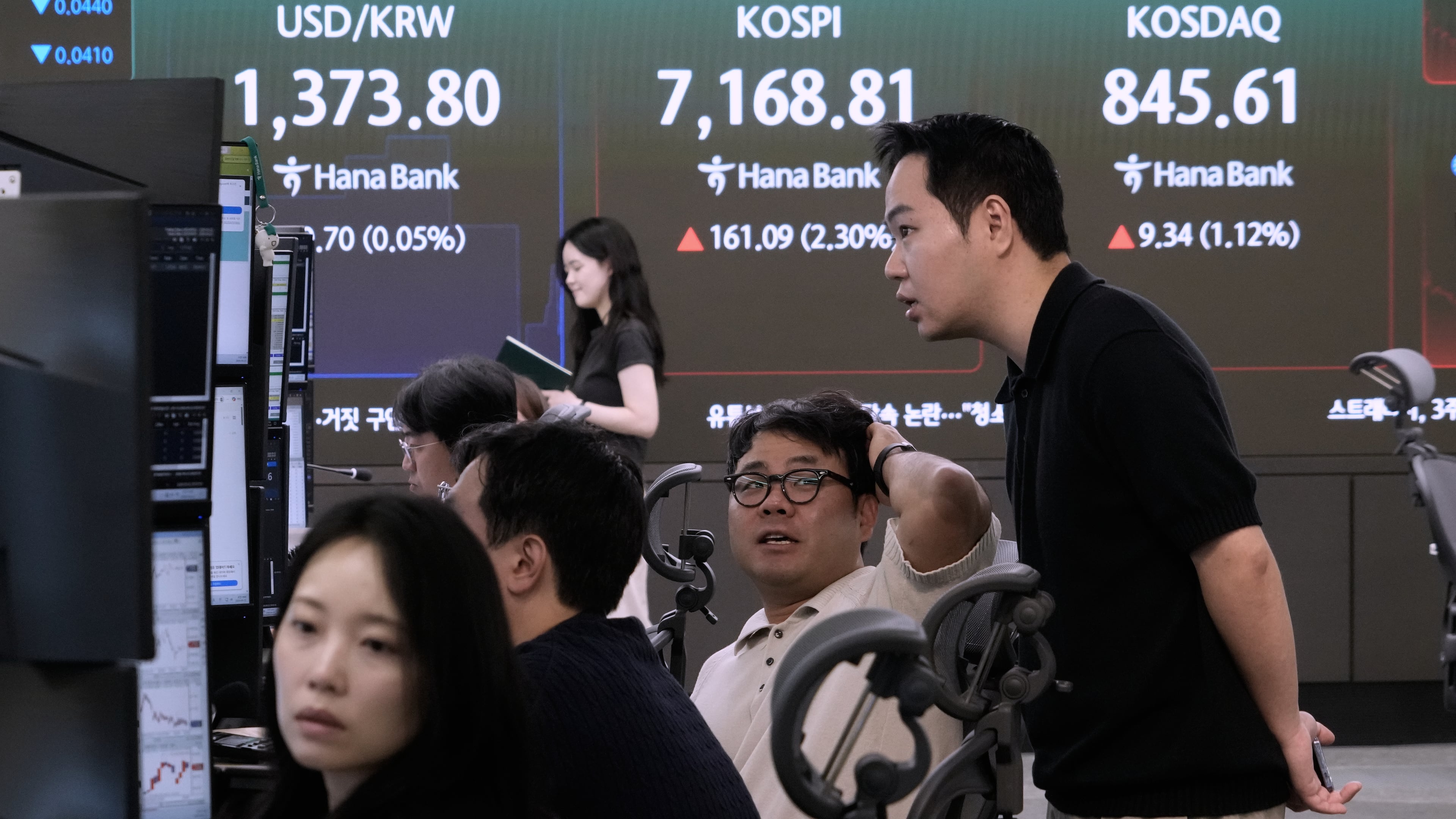 Currency traders work near a screen showing the Korea Composite Stock Price Index (KOSPI) and the foreign exchange rate between U.S. dollar and South Korean won at the foreign exchange dealing room of the Hana Bank headquarters in Seoul, South Korea, Tuesday, Sept. 22, 2026. (AP Photo/Ahn Young-joon)