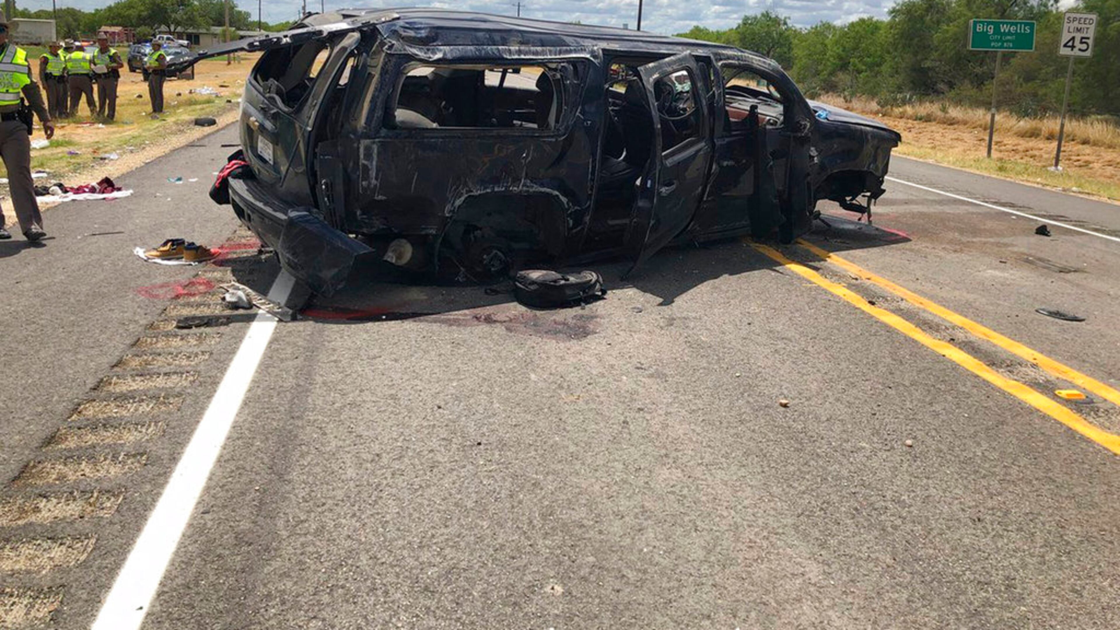 In this image tweeted by David Caltabiano of KABB/WOAI, a heavily damaged SUV is seen on Texas Highway 85 in Big Wells, Texas, after crashing while carrying more than a dozen people fleeing from Border Patrol agents, Sunday, June 17, 2018. (David Caltabiano/KABB/WOAI via AP)