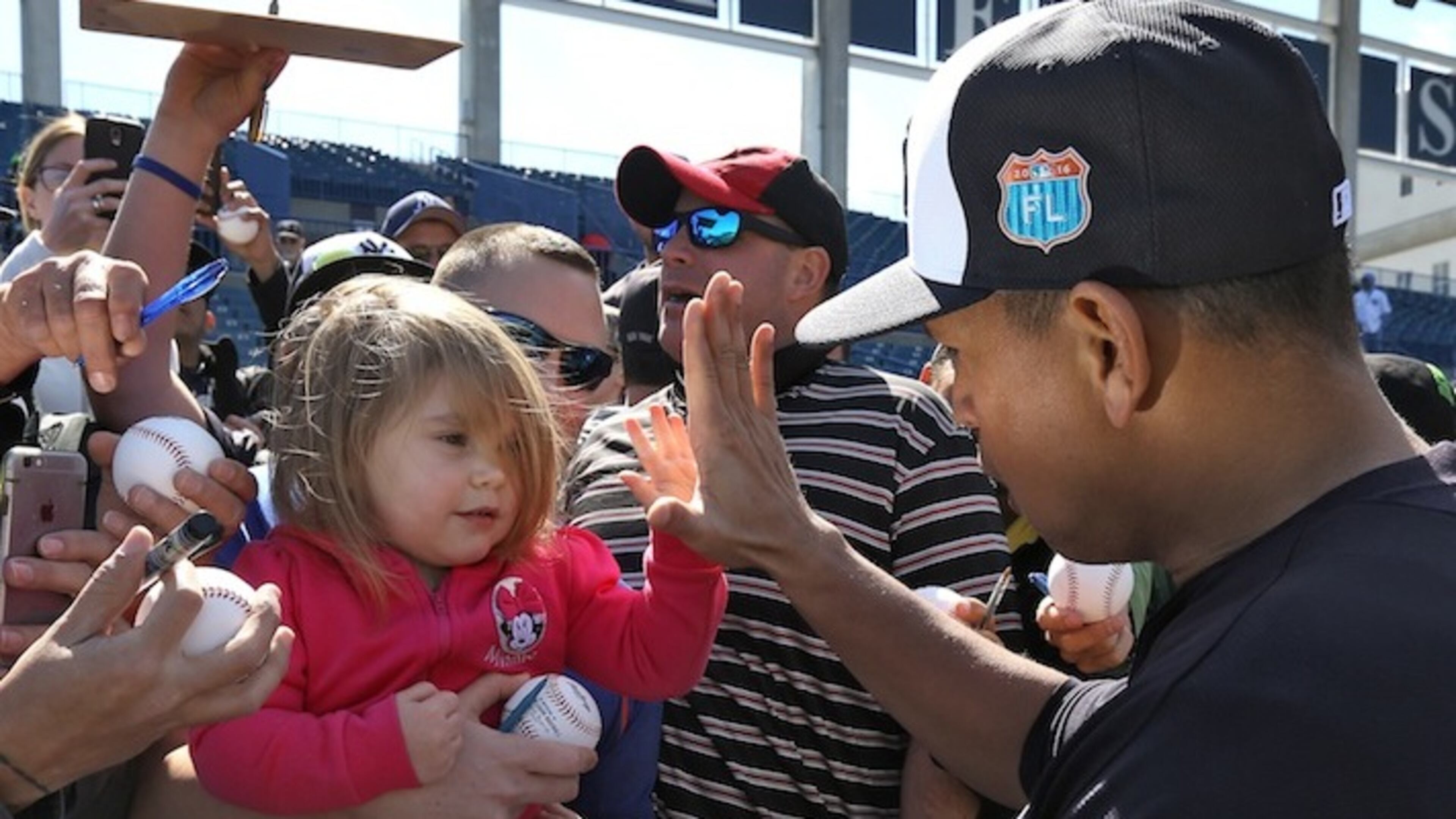New York Yankees Alex Rodriguez high fives a young fan while signing autographs during a spring training baseball workout Thursday, Feb. 25, 2016, in Tampa, Fla. (AP Photo/Chris O'Meara)