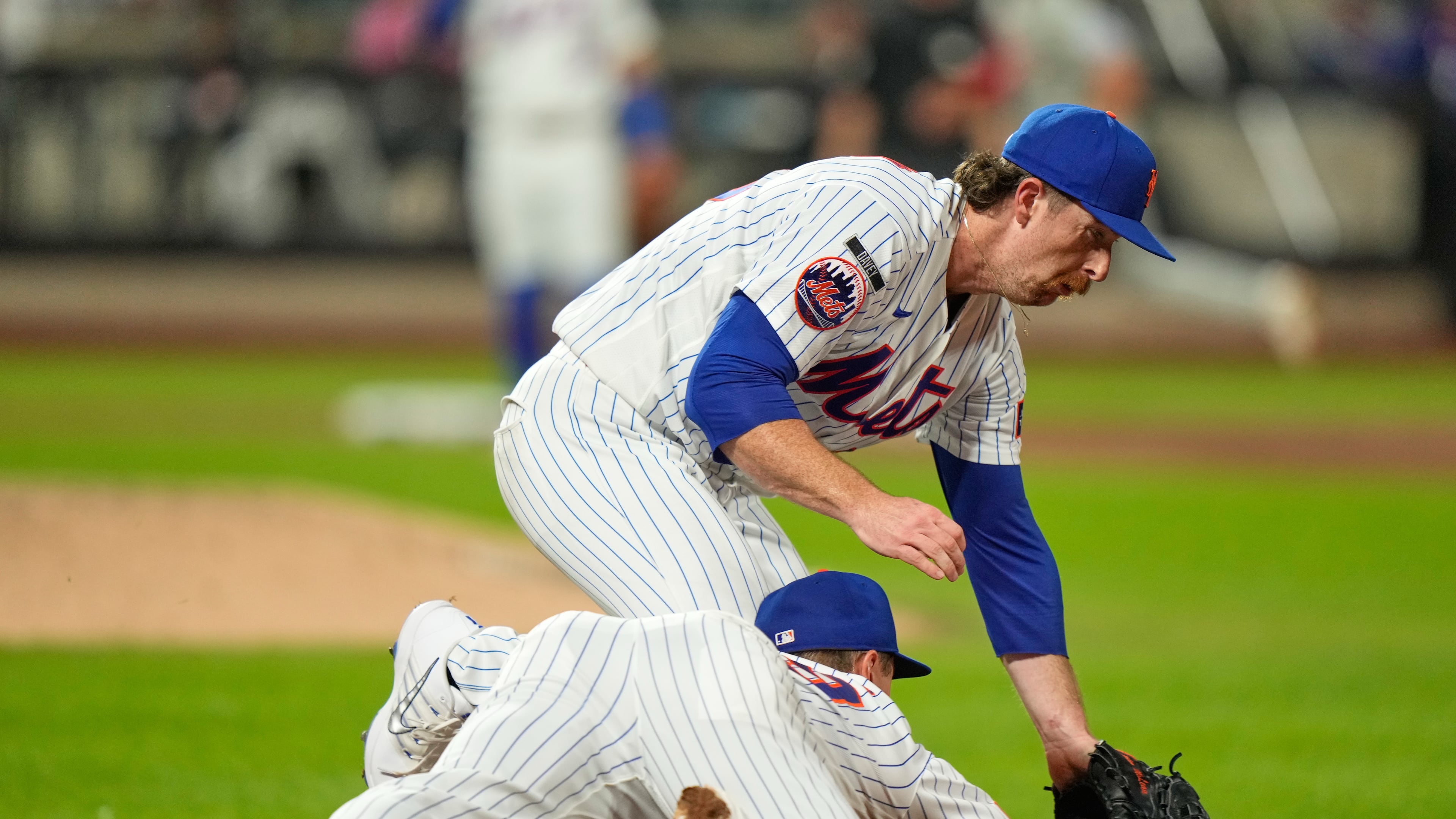 New York Mets pitcher Nolan McLean, top, collides with first baseman Jared Young as they chase a ball during the sixth inning of a baseball game against the Philadelphia Phillies, Thursday, Sept. 17, 2026, in New York. (AP Photo/Seth Wenig)