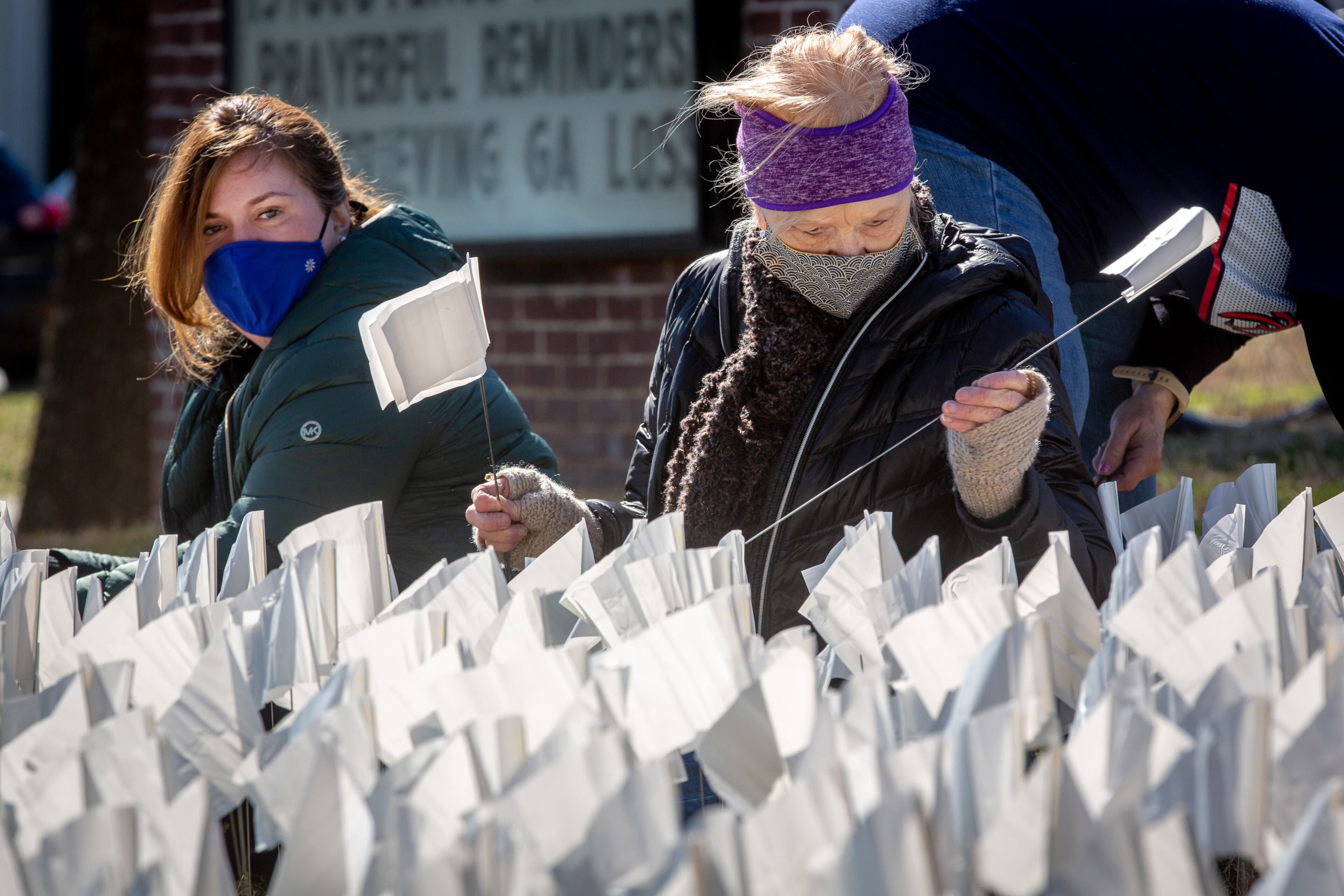 Susan Kenny (left) and Marsha Yenna plant some of the 15,000 flags on the lawn of First Christian Church of Decatur on Saturday, February 20, 2021. The flags represent the number of COVID-19 deaths in Georgia, and the effort aims to raise awareness about the toll of the coronavirus. (Photo: Steve Schaefer for The Atlanta Journal-Constitution)
